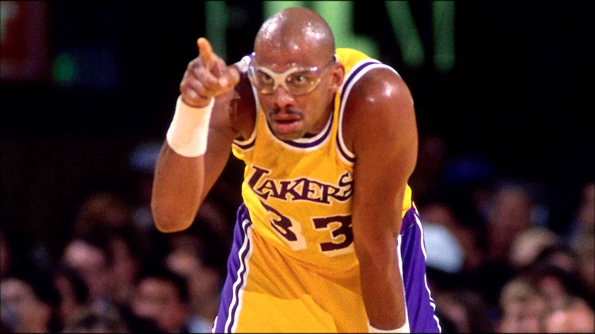 Kareem 桌布 壁紙 — 一位身穿黃色湖人隊球衣、背號33的籃球運動員，在明亮的場館燈光下比賽中激烈地向前指。