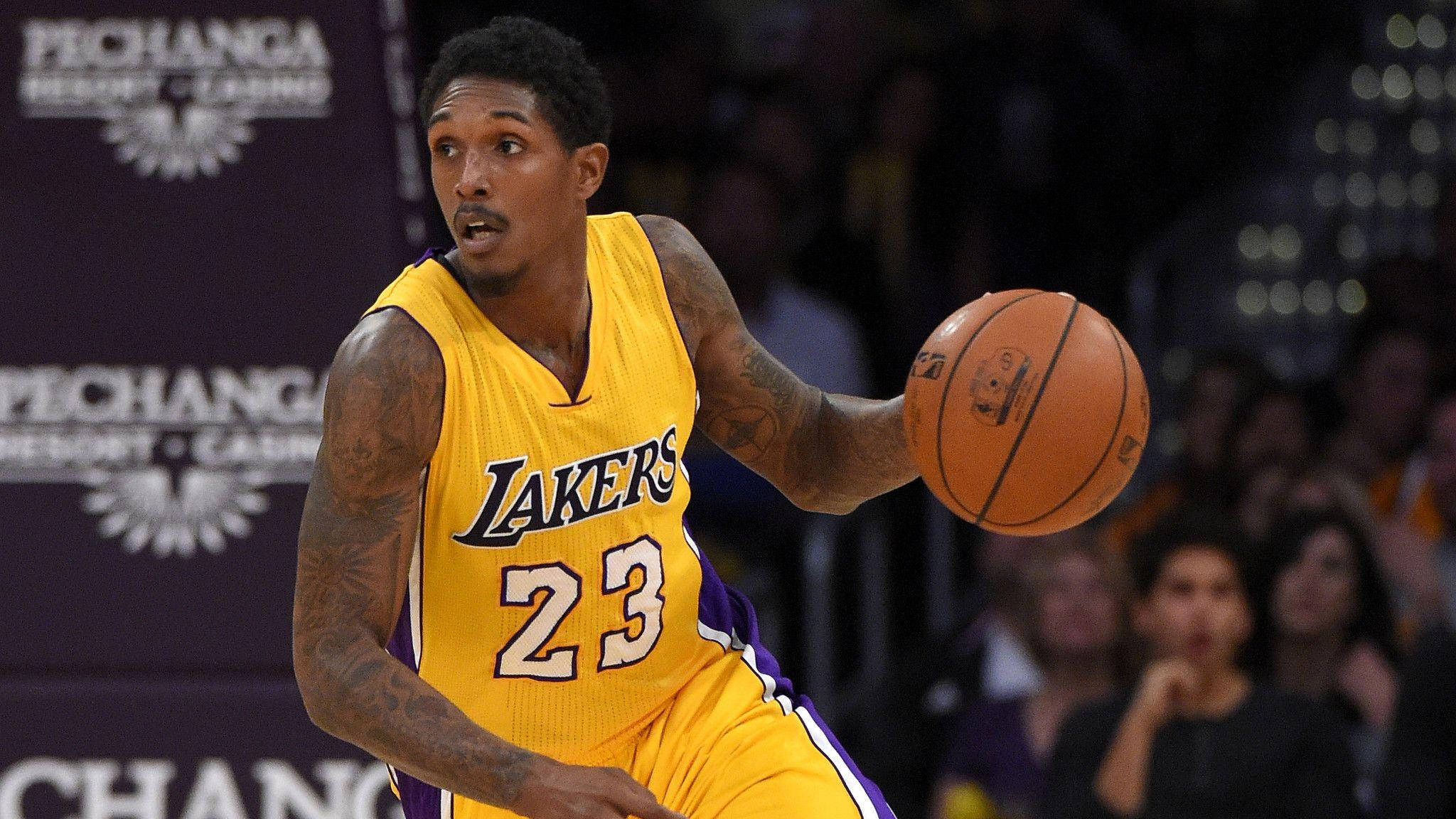 Lou Williams 桌布 壁紙 — 一位身穿黃色湖人隊球衣的籃球運動員在明亮的場館燈光下，於室內比賽中專注地運球。