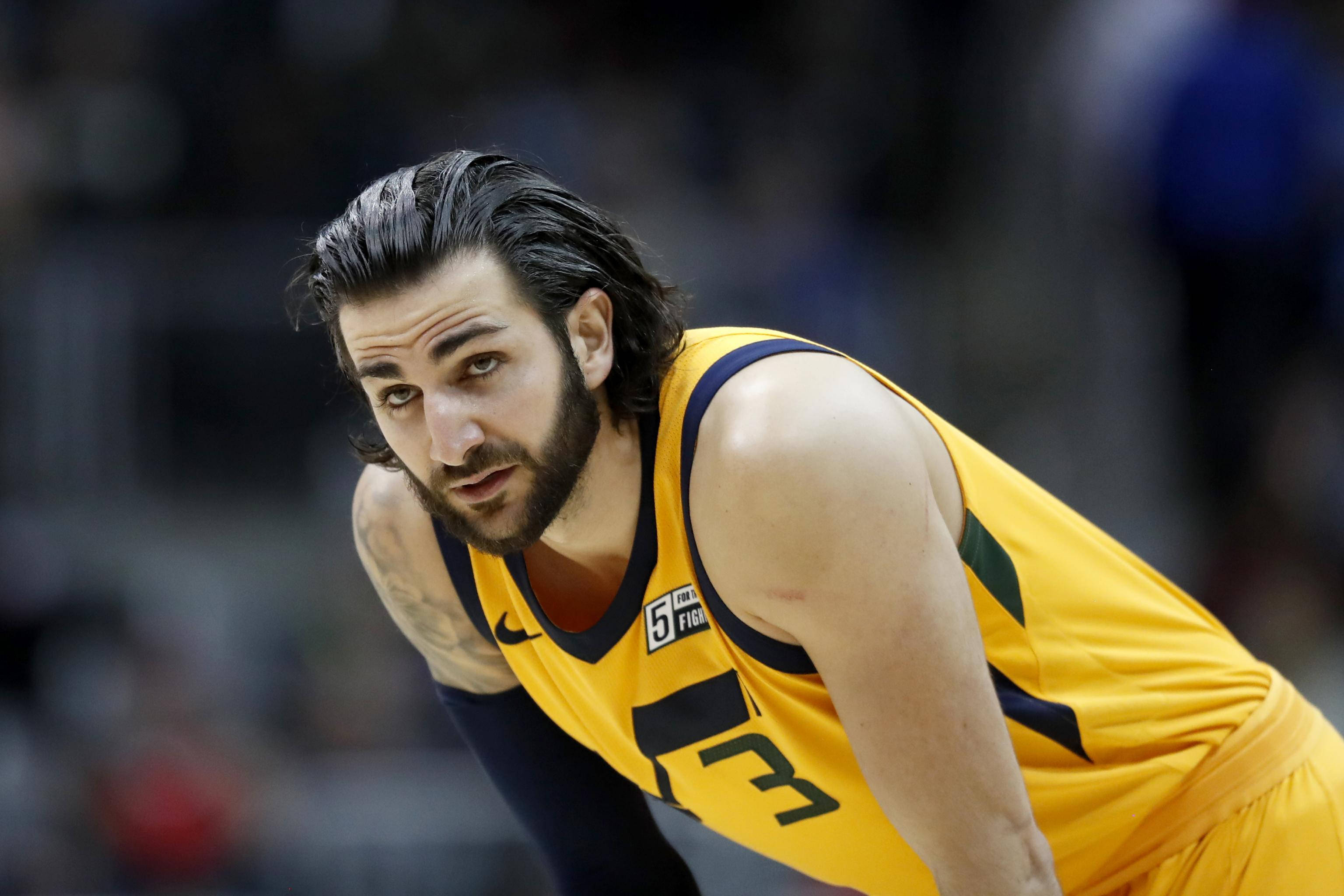 Ricky Rubio 桌布 壁紙 — 一位身穿黃色球衣、專注的籃球運動員在明亮的場館燈光下，於比賽中激烈地向前傾身。
