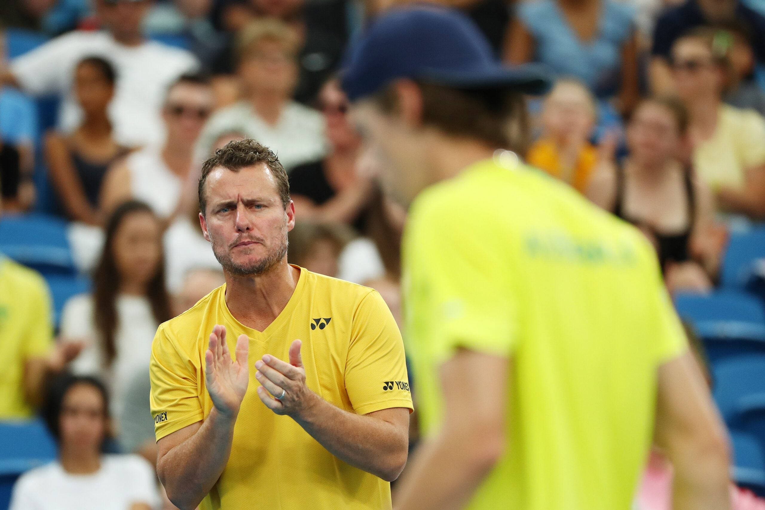 Australian Open 桌布 壁紙 — 一位身穿黃色襯衫的網球教練在比賽中面對一位身穿亮黃色襯衫的球員，熱烈地鼓掌。