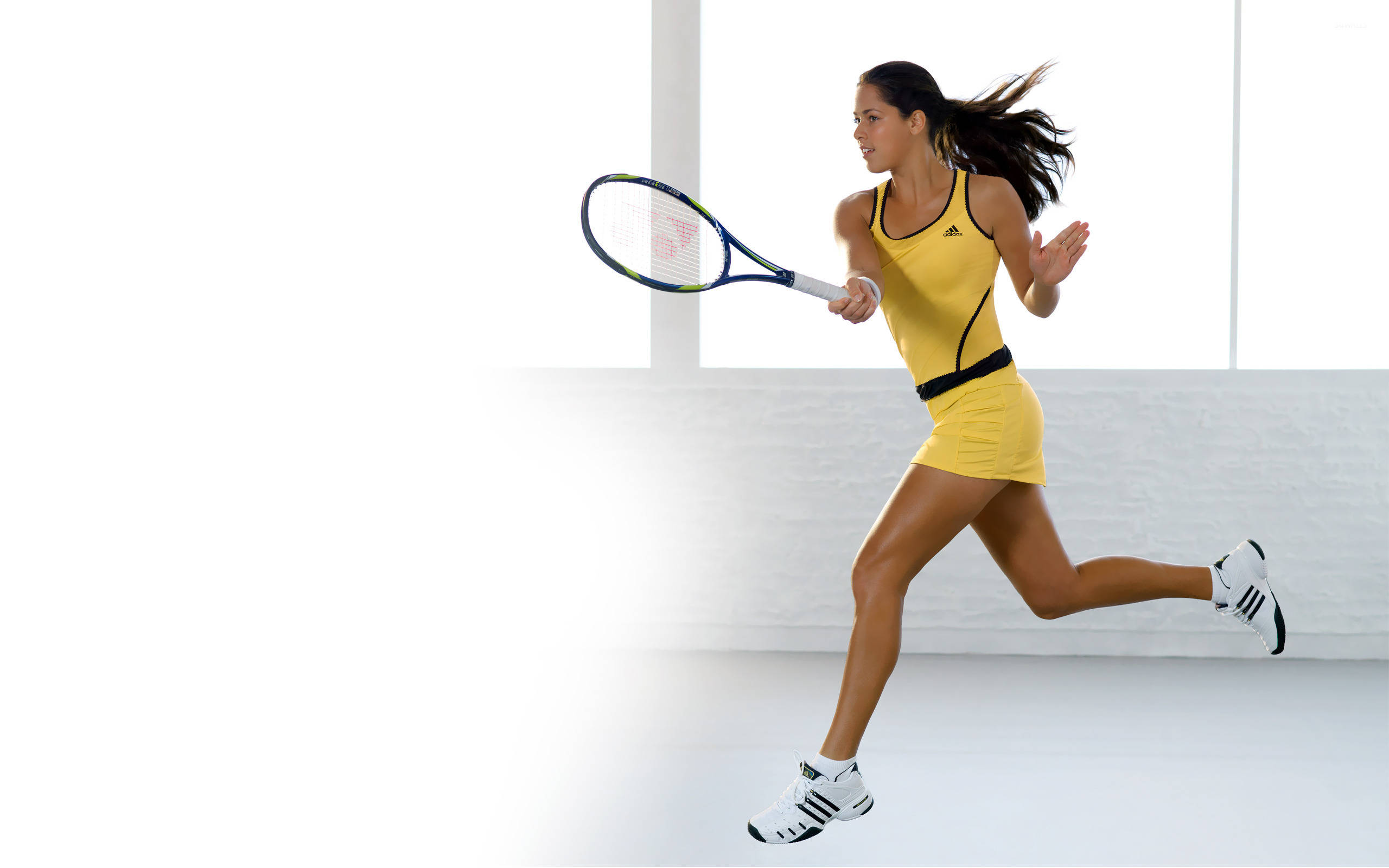 Fitness 桌布 壁紙 — 一位身穿黃色運動服的女網球運動員在明亮的白色工作室背景下向前衝刺，球拍蓄勢待發。