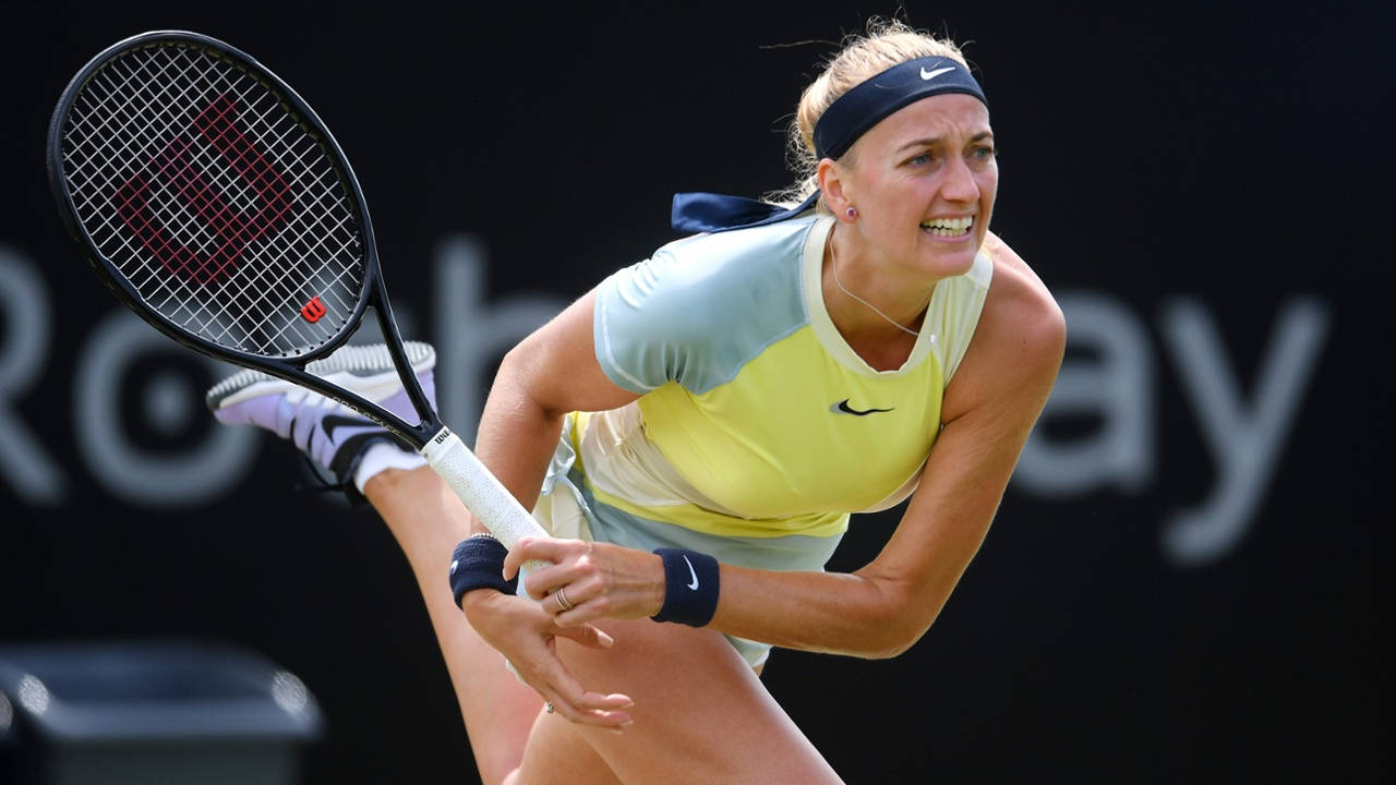 Nike 桌布 壁紙 — 一位身穿黃藍色球衣的女網球選手在黑暗的球場上揮拍，專注地向前撲擊。