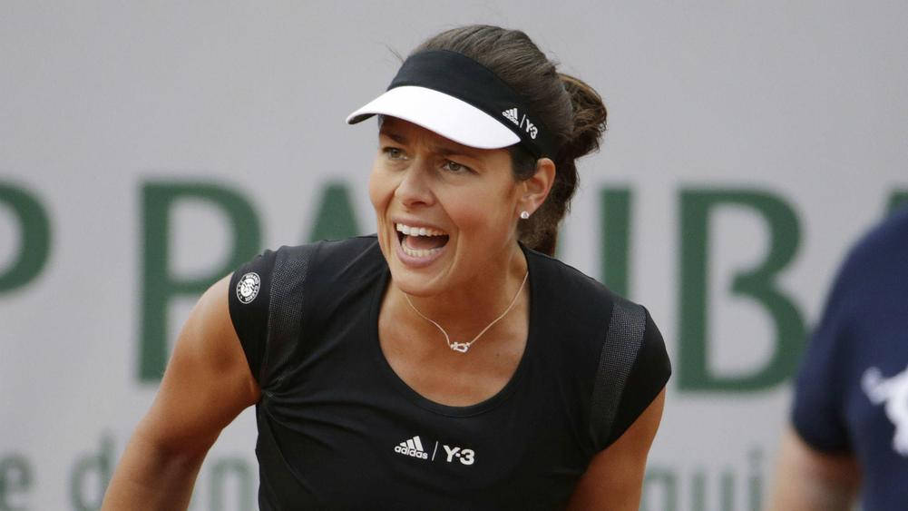 運動 桌布 壁紙 — 一位身穿黑色 adidas Y3 裝備的女網球選手在紅土場上開心大笑，身後有綠色標牌。