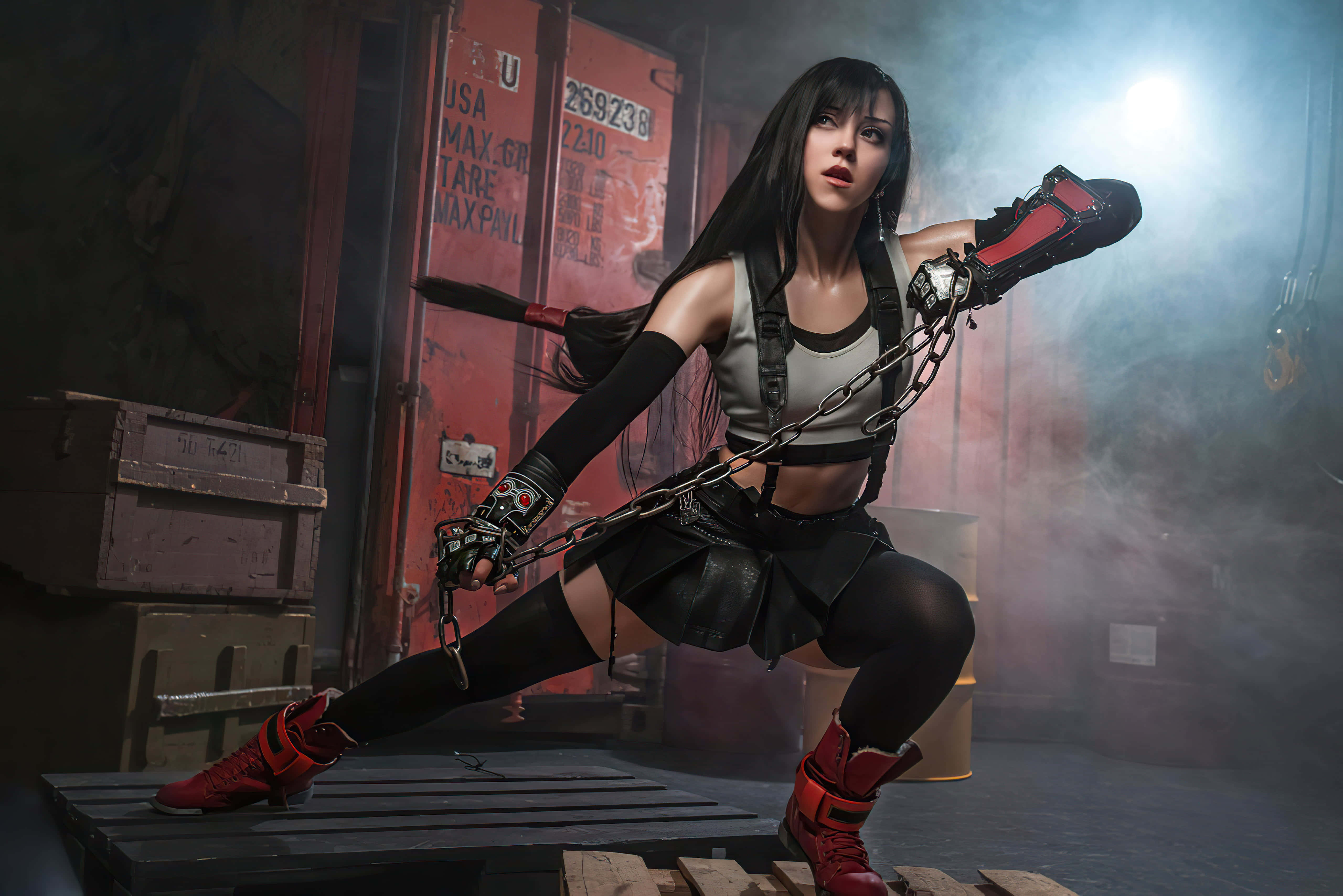 Gaming Cosplay 桌布 壁紙 — 一位身穿黑色和紅色裝備的兇猛女戰士，在煙霧瀰漫的工業倉庫中揮舞著鏈條武器。