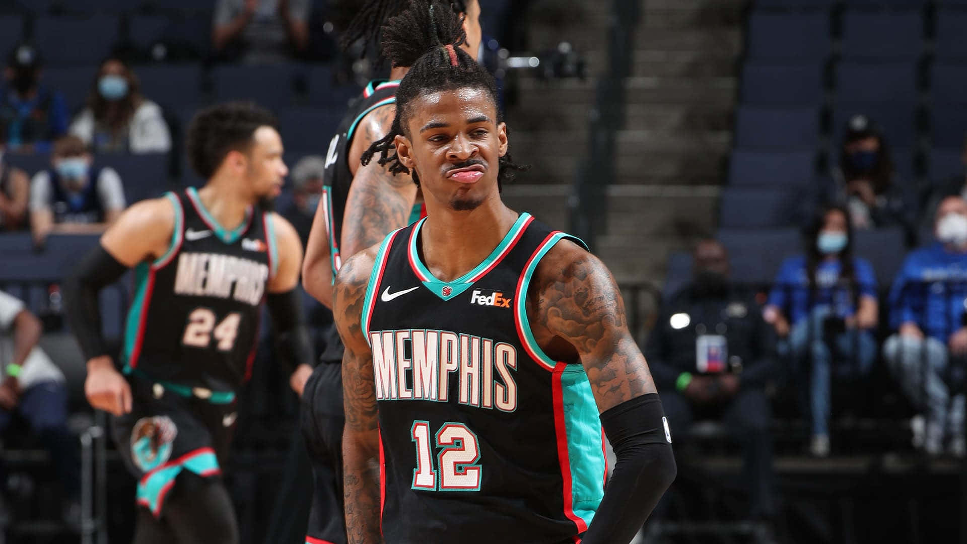 Ja Morant 動圖 桌布 壁紙 — 一位身穿黑色和青綠色球衣、背號12的曼菲斯灰熊籃球球員站在球場上，伸出舌頭，表情沮喪。
