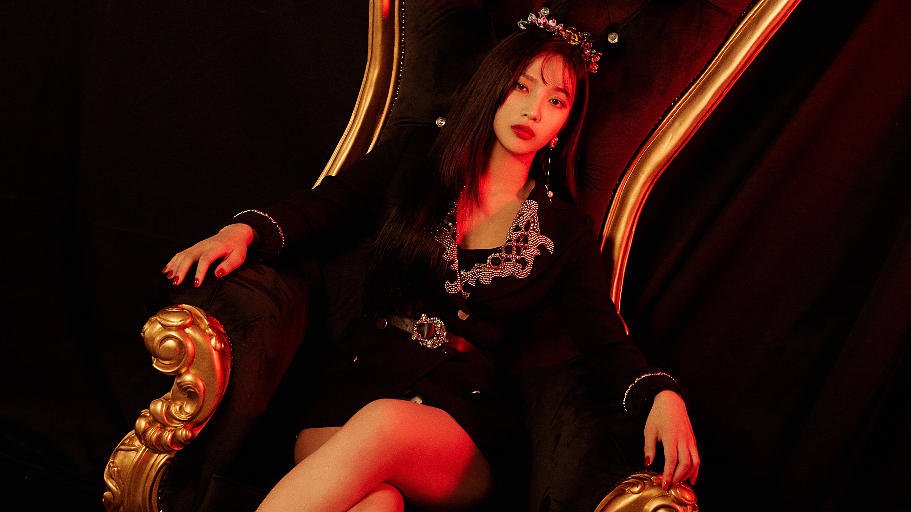 Velvet 桌布 壁紙 — 一位身穿黑色服裝、頭戴鑲寶石皇冠的女性，在紅色燈光的黑暗背景下，威嚴地坐在金色王座上。