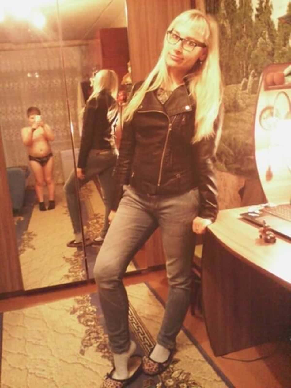 Woman 桌布 壁紙 — 一位身穿黑色皮夾克和牛仔褲的女性，在一個燈光溫暖、鋪有華麗地毯和鏡面牆的房間裡自信地擺姿勢。