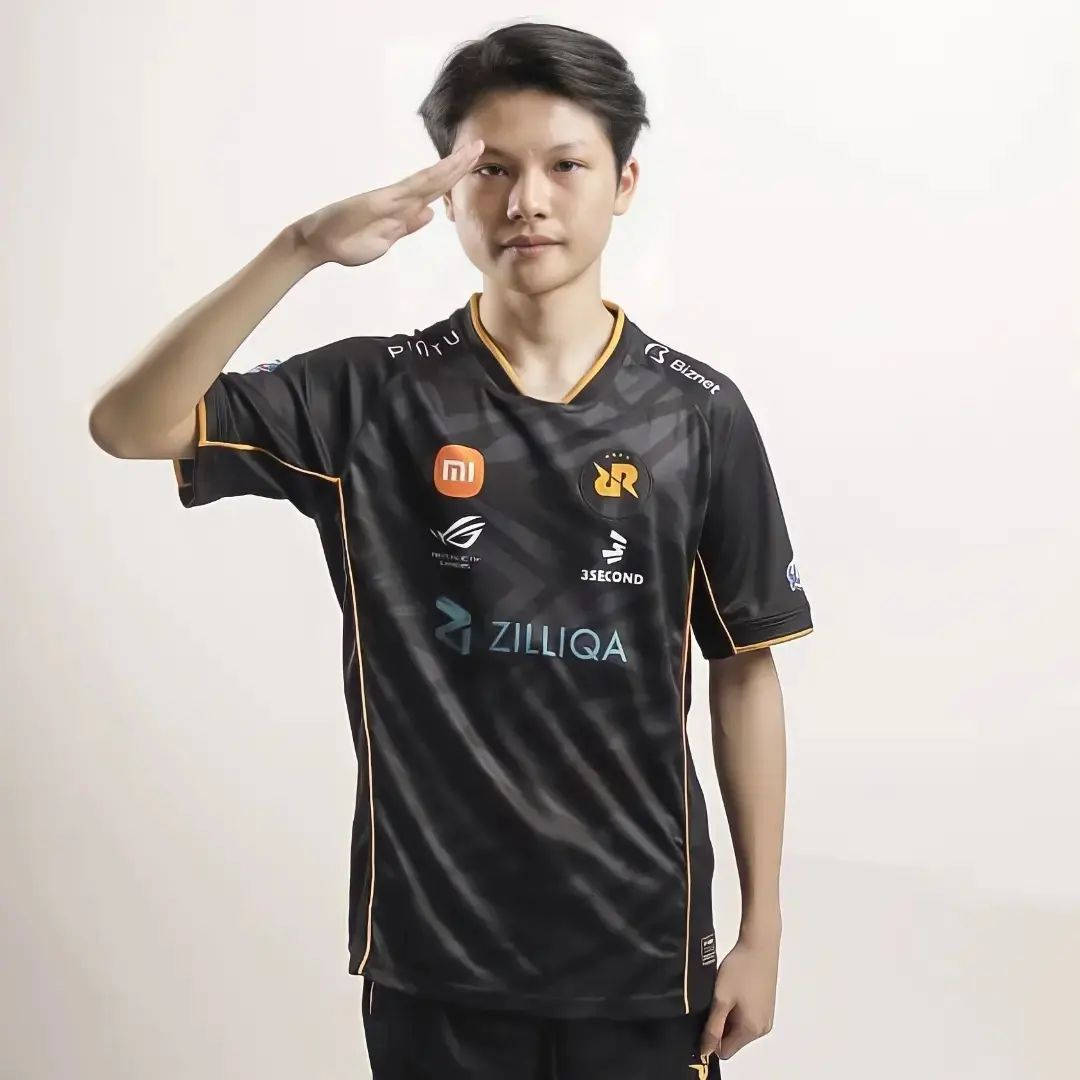 Team 桌布 壁紙 — 一位身穿黑金色隊服的年輕電競運動員在純色攝影棚背景下自信地敬禮。