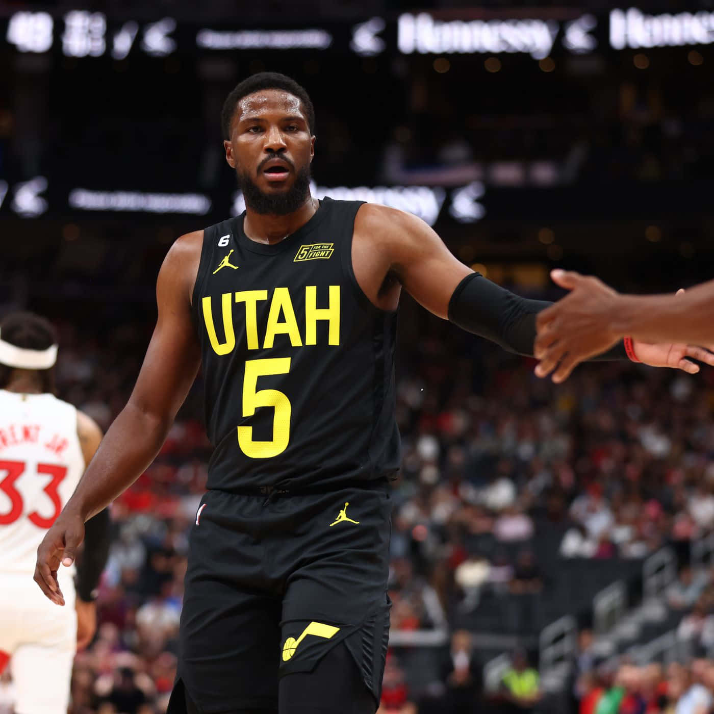 猶他爵士球員在籃球比賽中與隊友握手。 — NBA 壁紙