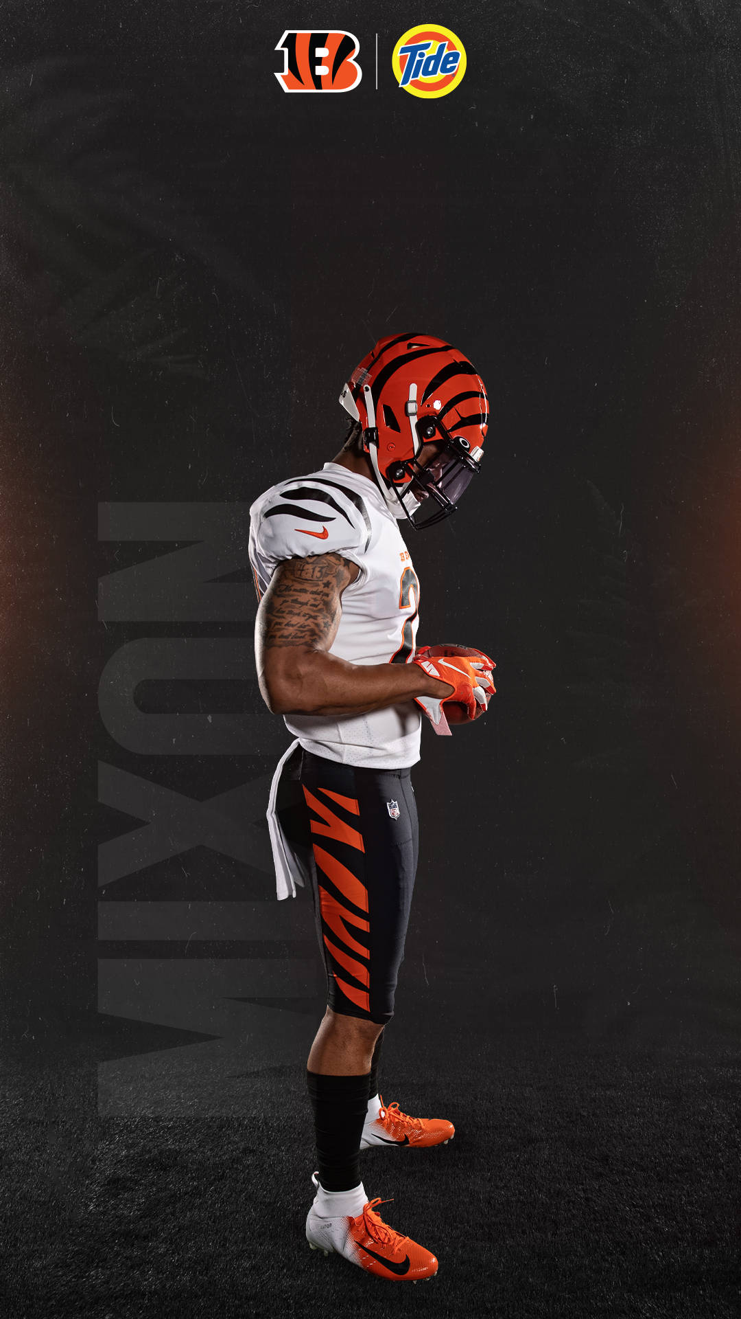 Bengals 桌布 壁紙 — 一位辛辛那提猛虎隊美式足球員身穿白色和橙色球衣，側身站在深色紋理背景前，背景上有球隊和 Tide 標誌。