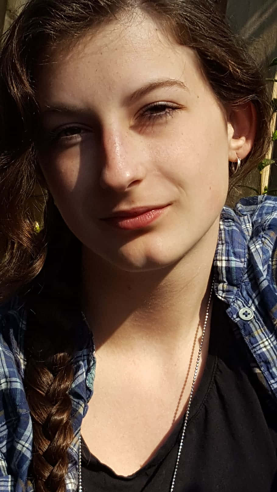 Woman 桌布 壁紙 — 一位辮子髮型的年輕女性在溫暖陽光下微笑，穿著格紋襯衫。