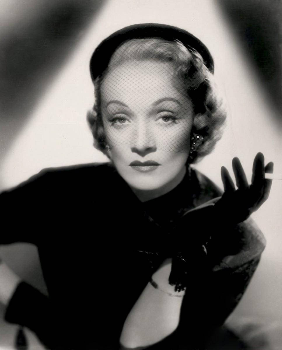 Marlene Dietrich 桌布 壁紙 — 一位迷人的復古好萊塢明星，身著面紗和手套，在黑白工作室肖像中，燈光戲劇性。
