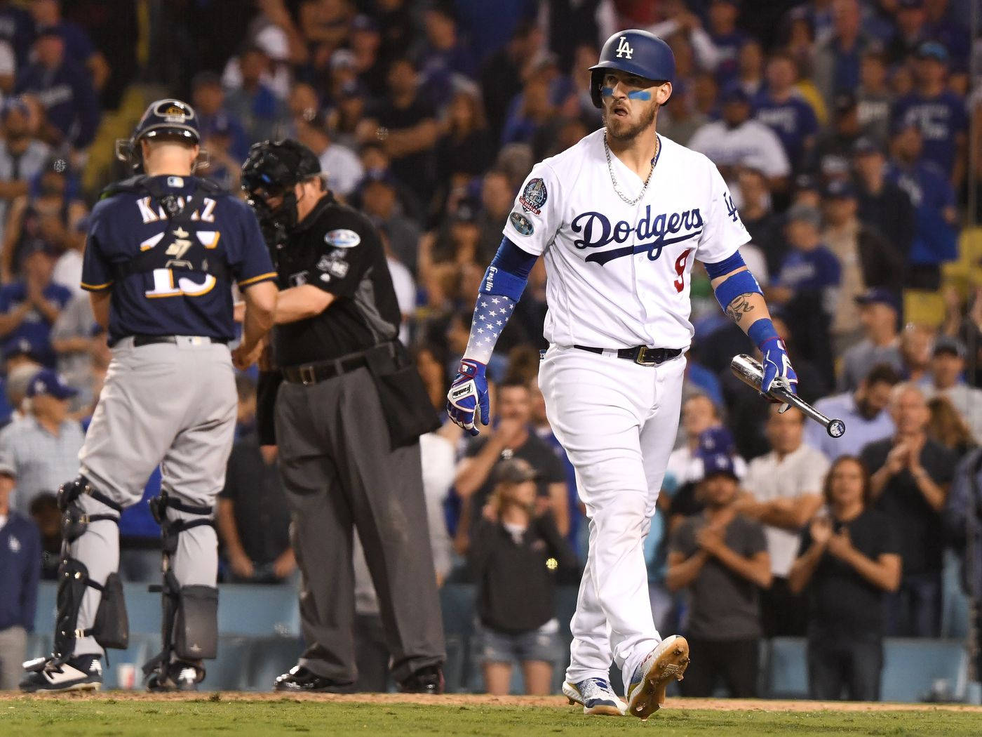 MLB 桌布 壁紙 — 一位道奇棒球運動員在夜間手持球棒離開球場，背景中球迷歡呼。