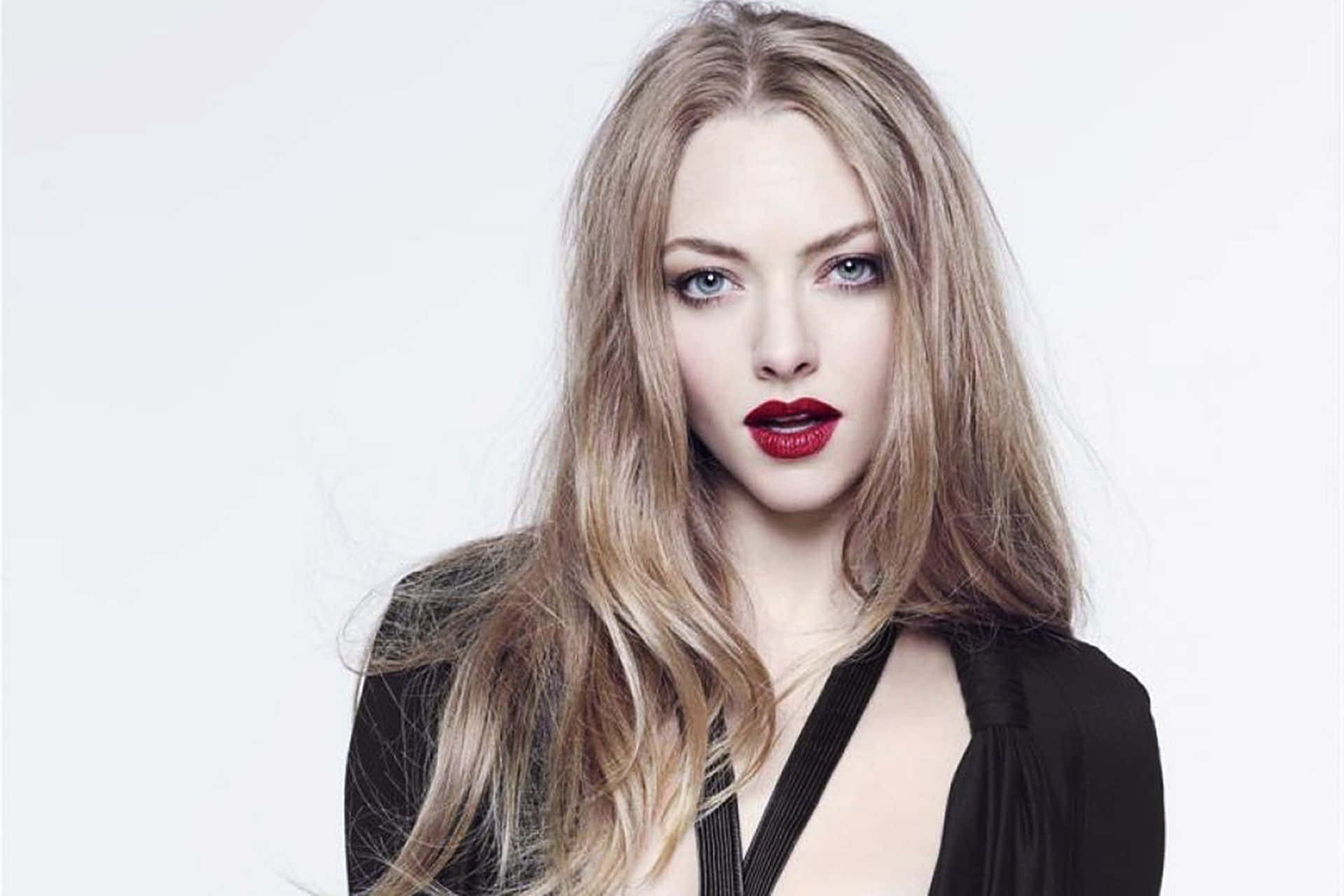 Amanda Seyfried 桌布 壁紙 — 一位金髮、紅唇大膽的女性在純白背景上的引人注目肖像。