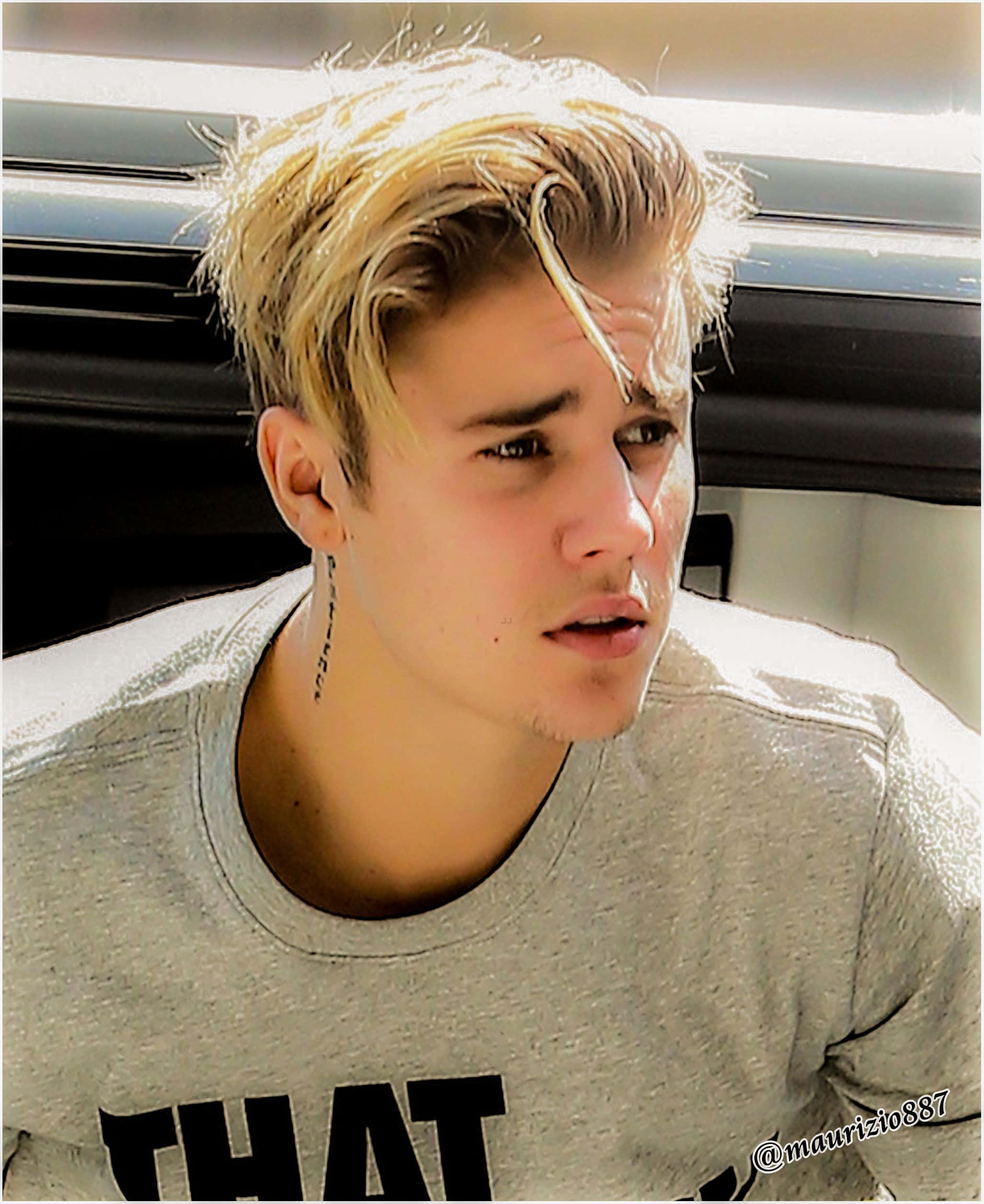 Justin Bieber 2015 桌布 壁紙 — 一位金髮、頸部有刺青的年輕男子，在陽光充足的房間裡穿著灰色T恤，視線離開鏡頭。