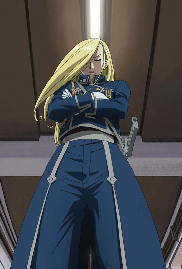Olivier Mira Armstrong 桌布 壁紙 — 一位金髮動漫士兵身穿藍色制服，在光線昏暗的走廊中交叉雙臂站立。