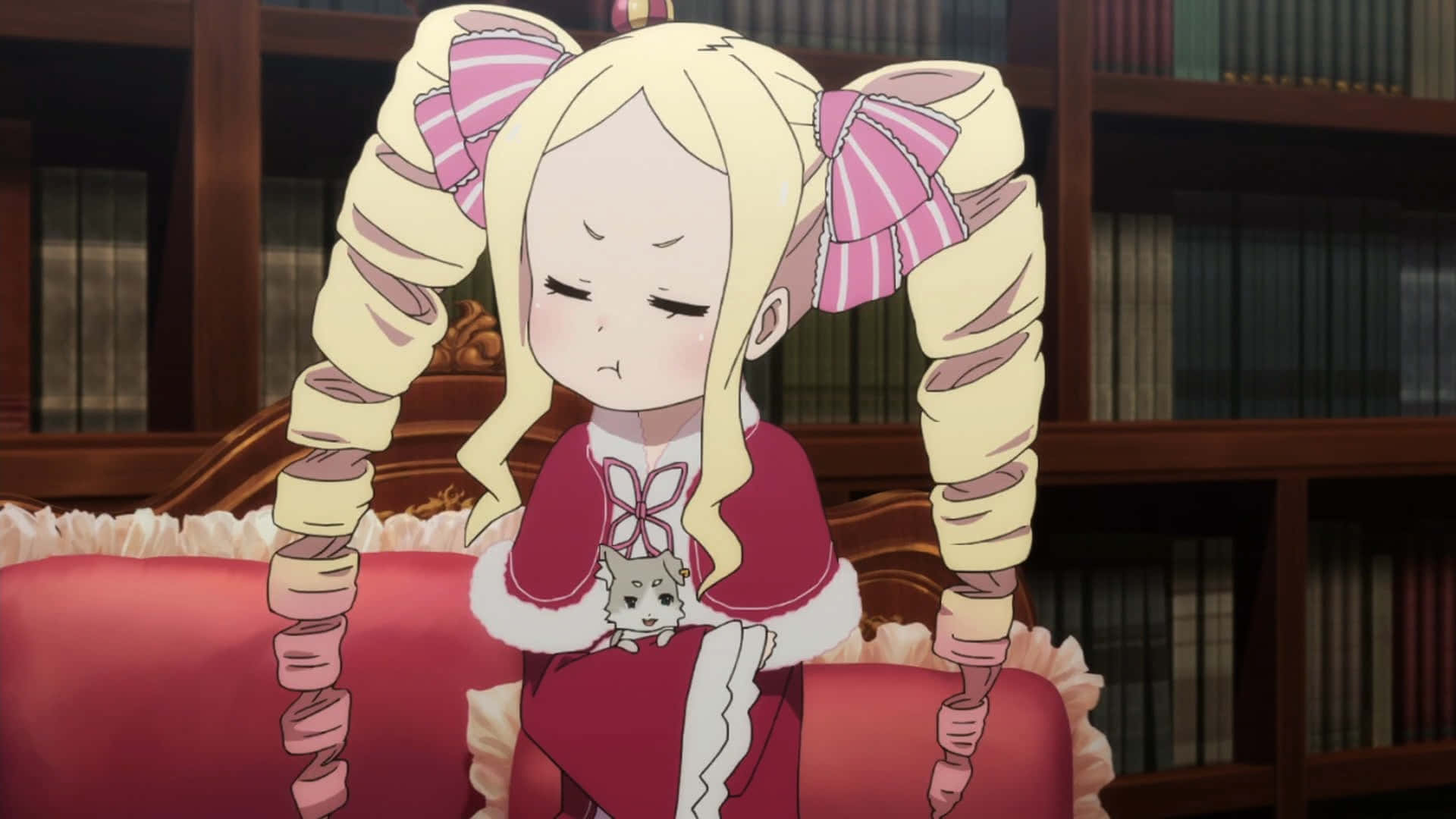 Re Zero Beatrice 桌布 壁紙 — 一位金髮動漫女孩，紮著巨大的粉紅色蝴蝶結雙馬尾，坐在圖書館的紅色沙發上，抱著一隻小貓。