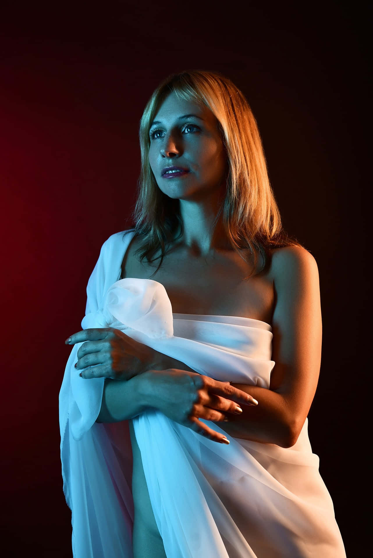 Photoshoot 桌布 壁紙 — 一位金髮女子包裹在白色布料中，站在深紅色背景前，在戲劇性燈光下。