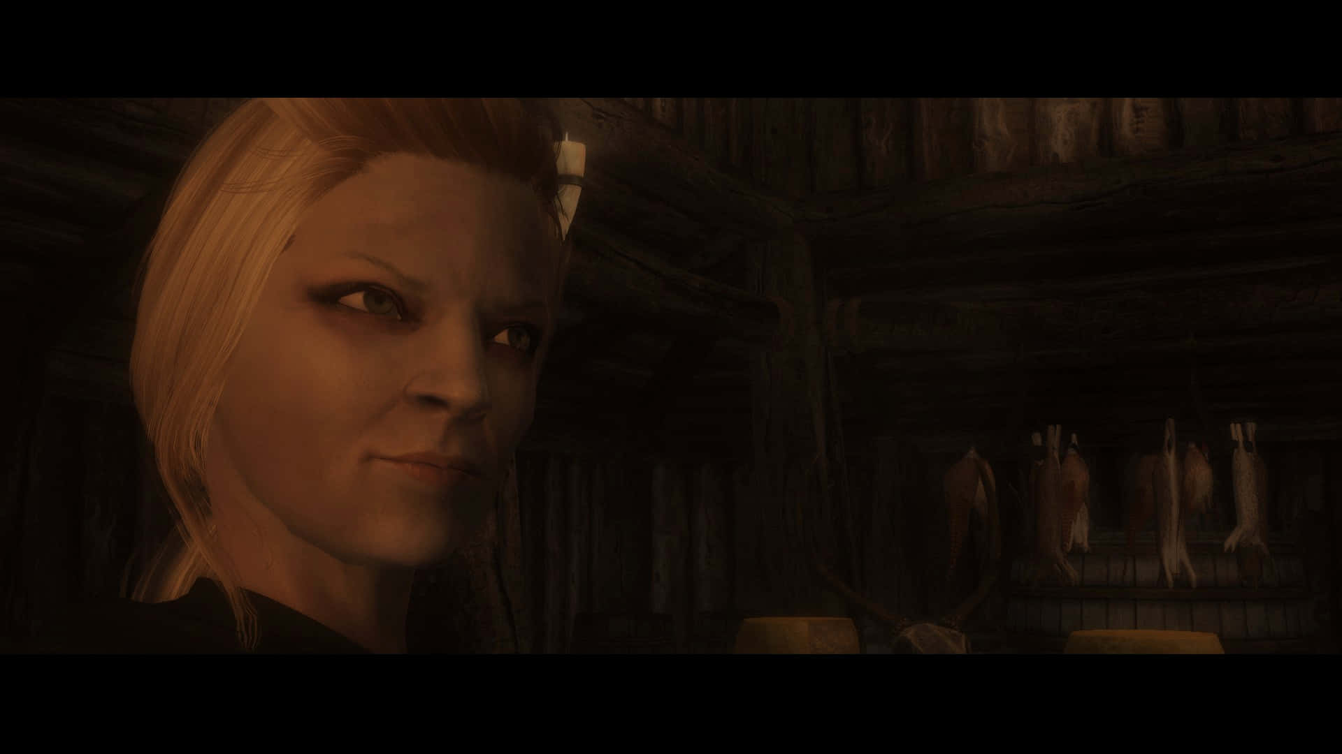 Skyrim Delphine 桌布 壁紙 — 一位金髮女子在掛著動物皮毛的昏暗木屋中凝視，眼神銳利。