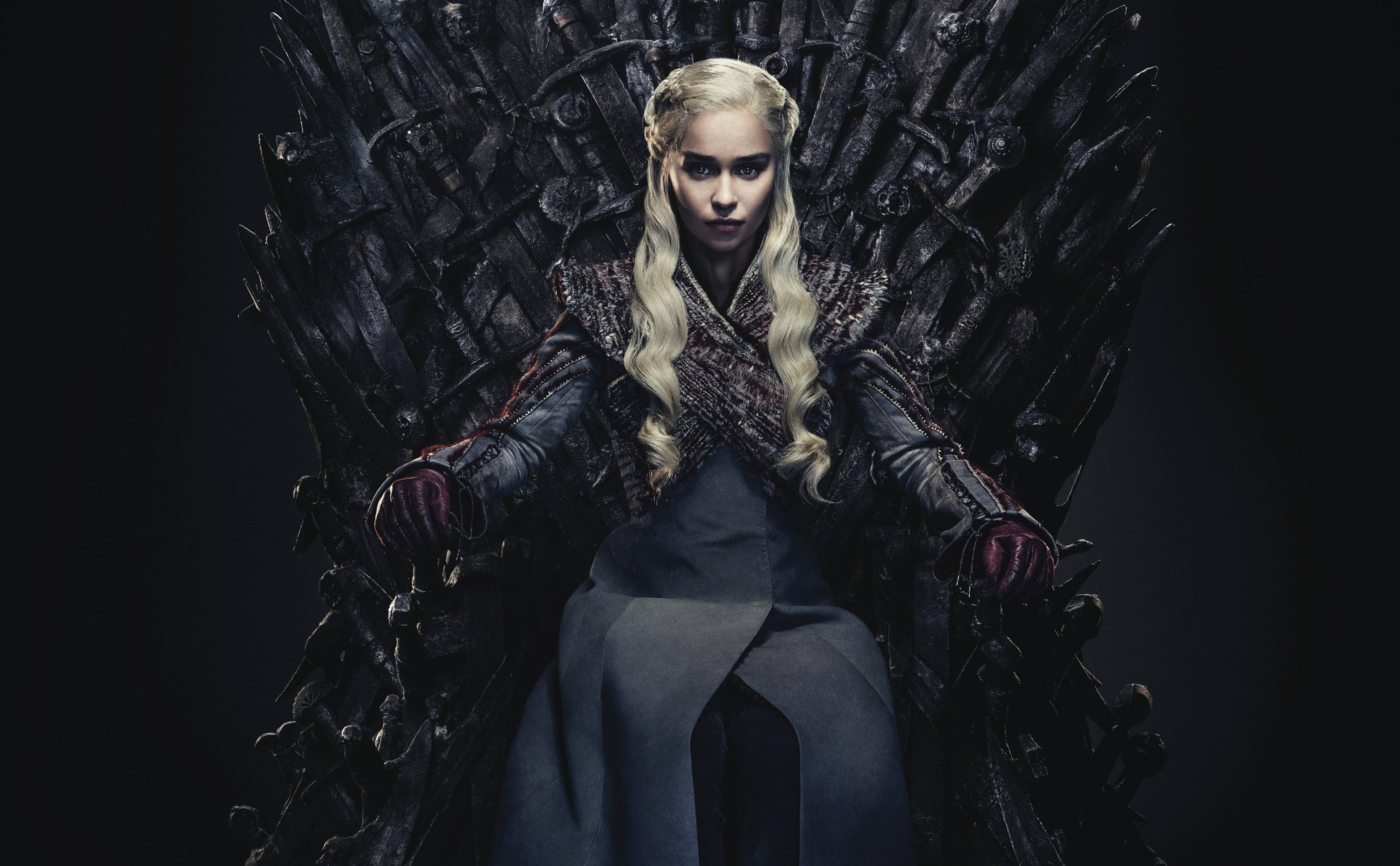 daenerys 桌布 壁紙 — 一位金髮女子身穿深色長袍，威嚴地坐在由劍組成的鐵王座上，背景為黑色。