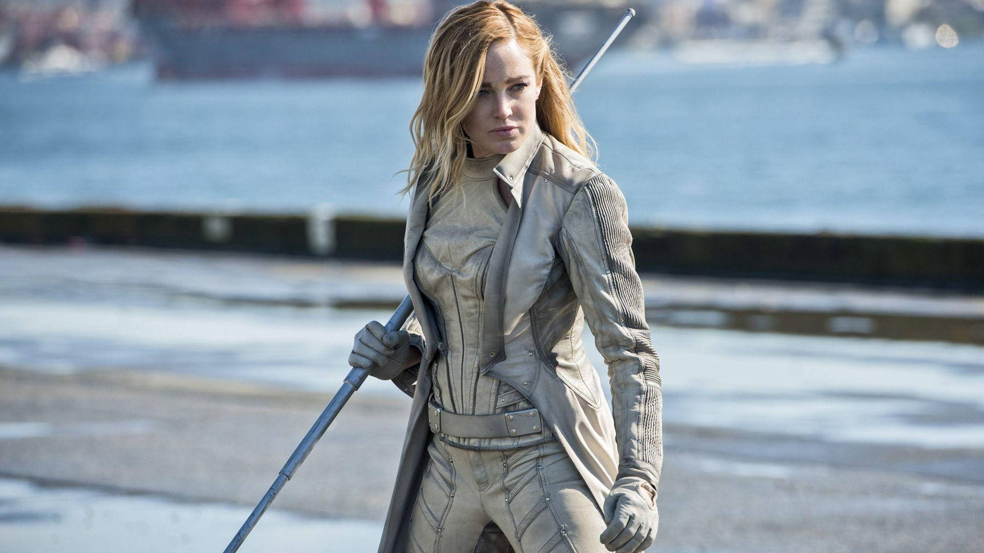 金髮女子身穿米色戰術服在碼頭手持法杖。 — Caity Lotz 動圖 壁紙