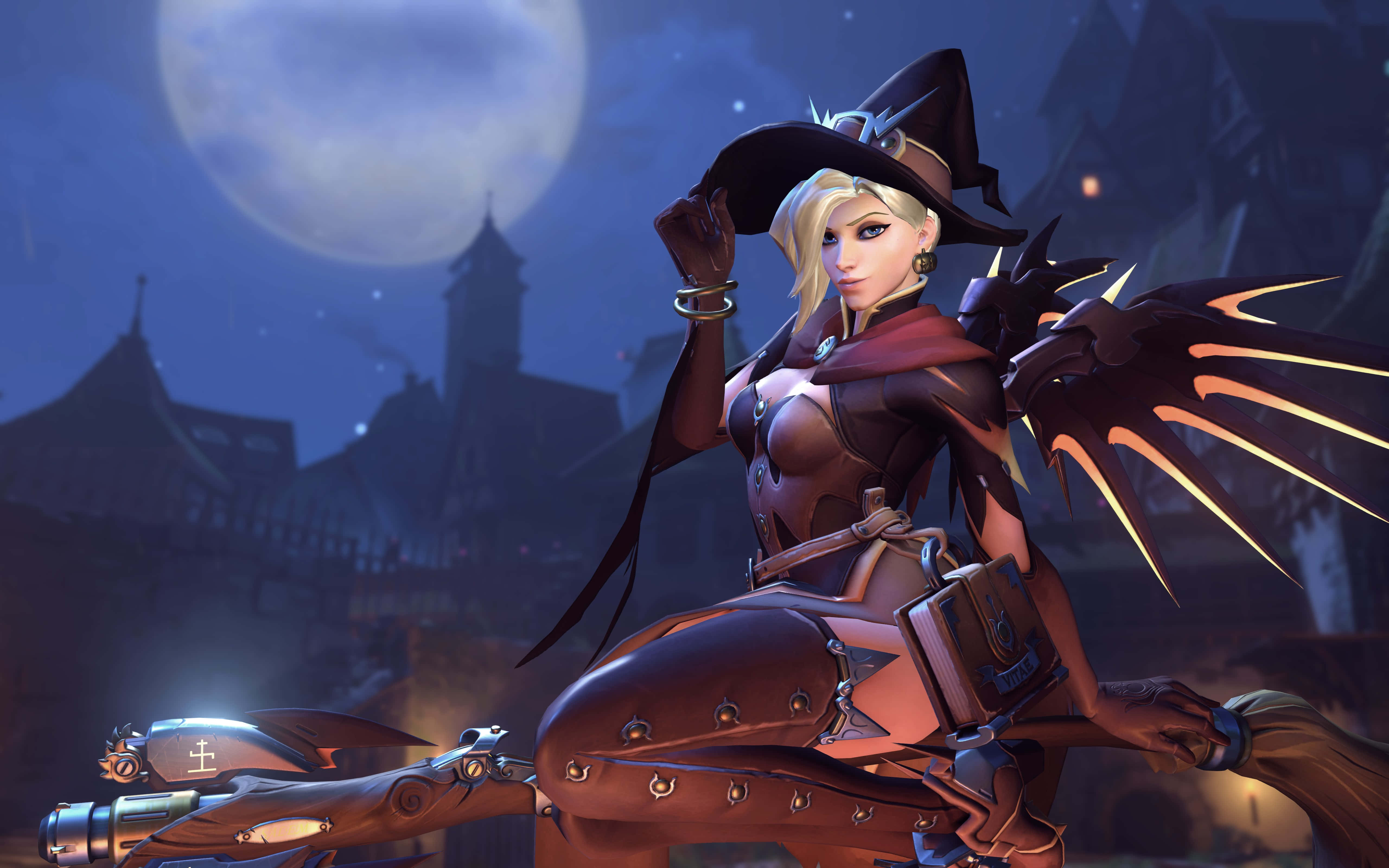 Overwatch Mercy 桌布 壁紙 — 一位金髮女巫戴著黑色帽子、穿著皮革服裝，在滿月下騎著掃帚飛越哥德式村莊。