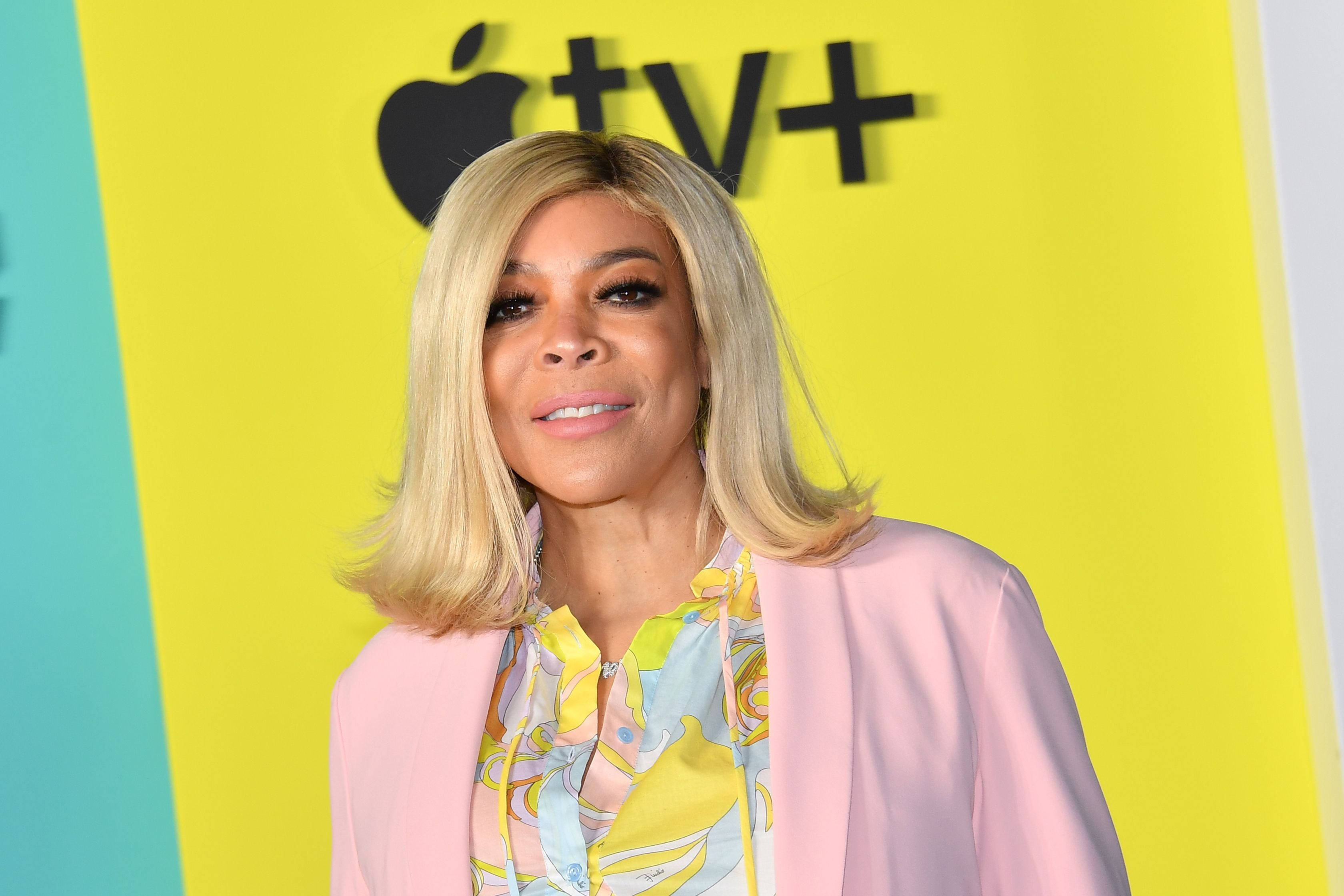 Celebrity 桌布 壁紙 — 一位金髮女性在明亮的黃色Apple TV+品牌背景前微笑。