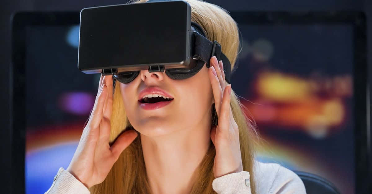 vr 桌布 壁紙 — 一位金髮女性戴上VR頭戴式裝置，雙手握持，沉浸在色彩繽紛的數位世界中。
