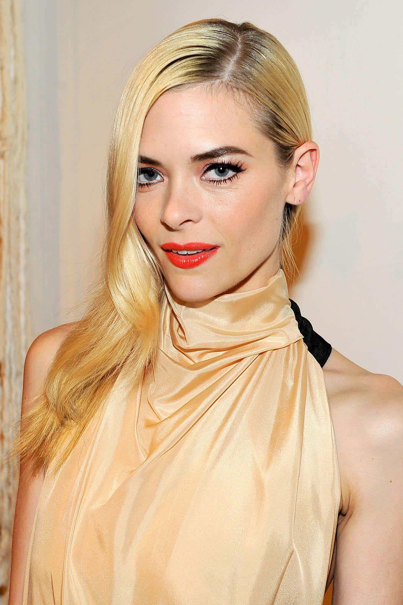 Jaime King 桌布 壁紙 — 一位金髮女性的特寫肖像，她有鮮紅色嘴唇和優雅的金色緞面服裝，背景是柔和的中性色調。
