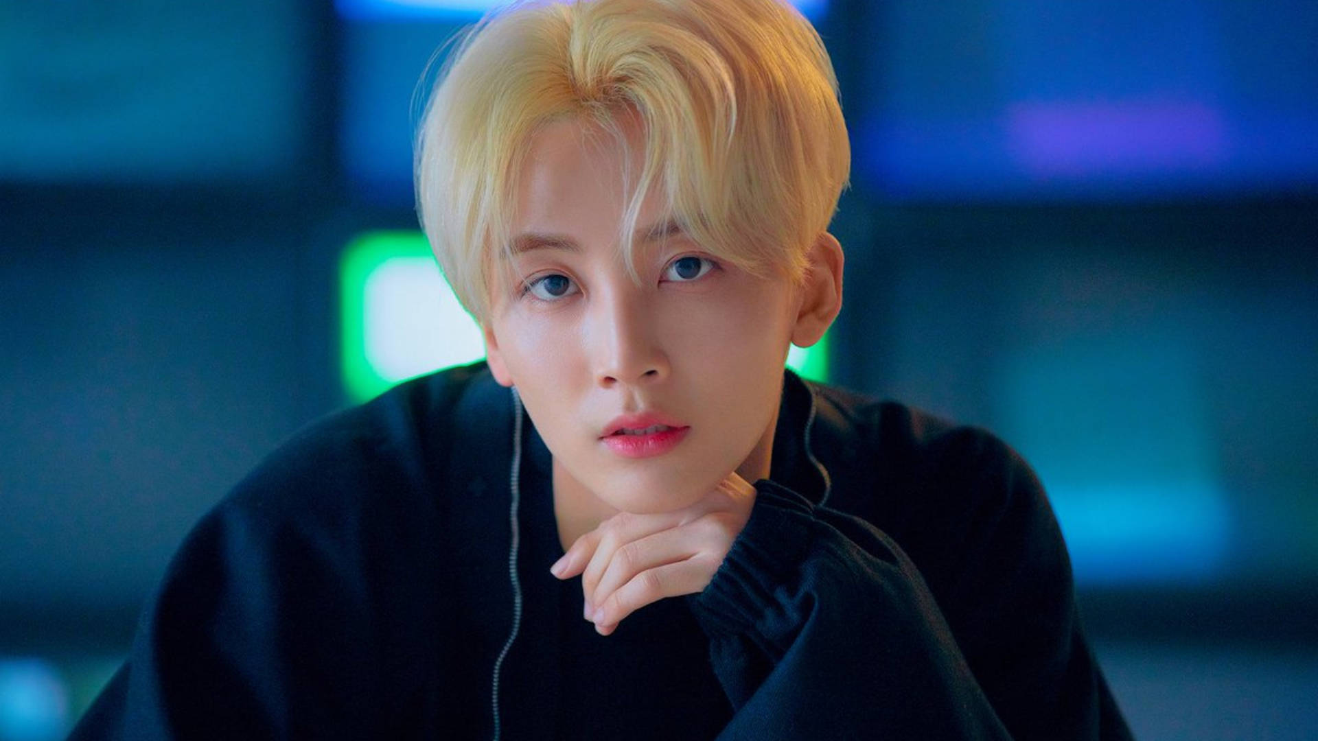 yoon jeonghan 桌布 壁紙 — 一位金髮年輕人將下巴靠在手上，背景是發光的藍色和綠色霓虹燈。