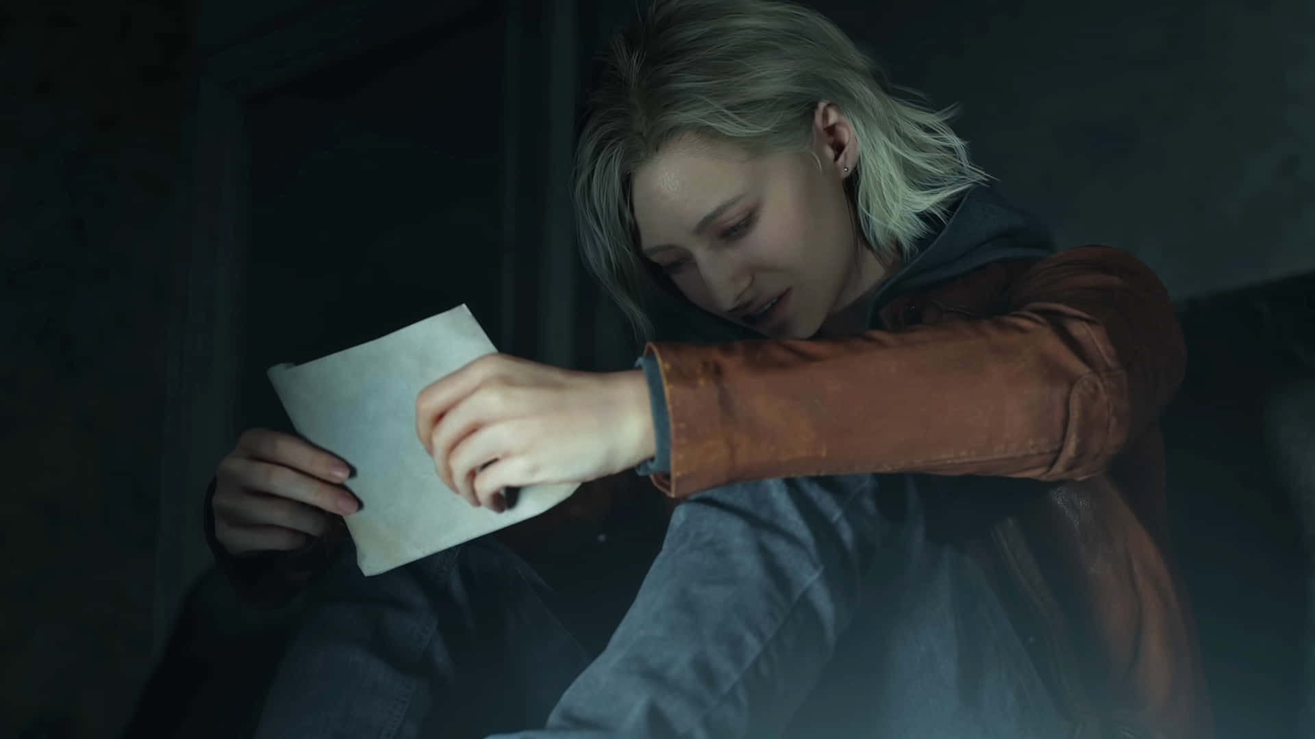 Resident Evil Requiem Grace Ashcroft 壁紙 — 一位金髮年輕女性在昏暗的房間裡向前傾，專注地拿著一張皺巴巴的便條。