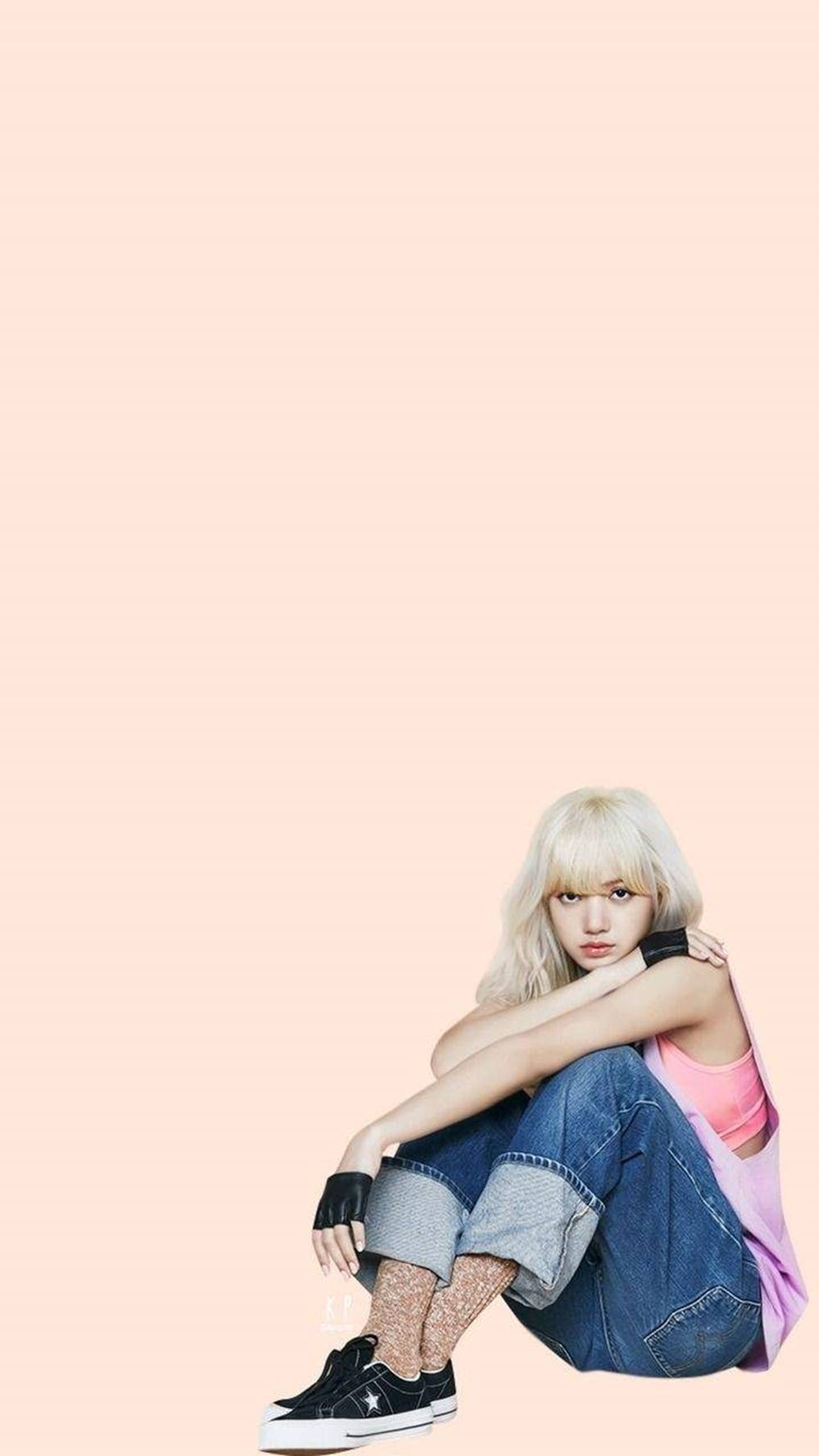 一位金髮年輕女性盤腿坐在桃色背景前，穿著牛仔褲和運動鞋。 — BLACKPINK Lisa GIF 壁紙