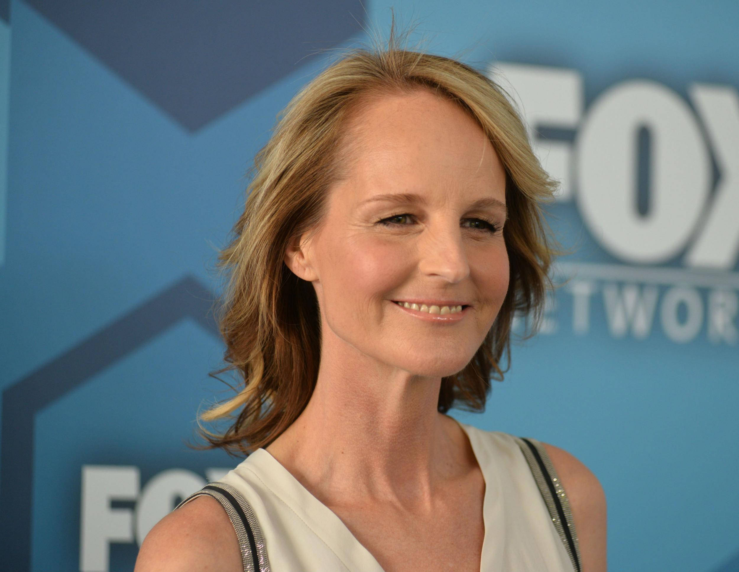 Celebrity 桌布 壁紙 — 一位金髮微笑的女性站在活動現場的藍色FOX Network背景前。