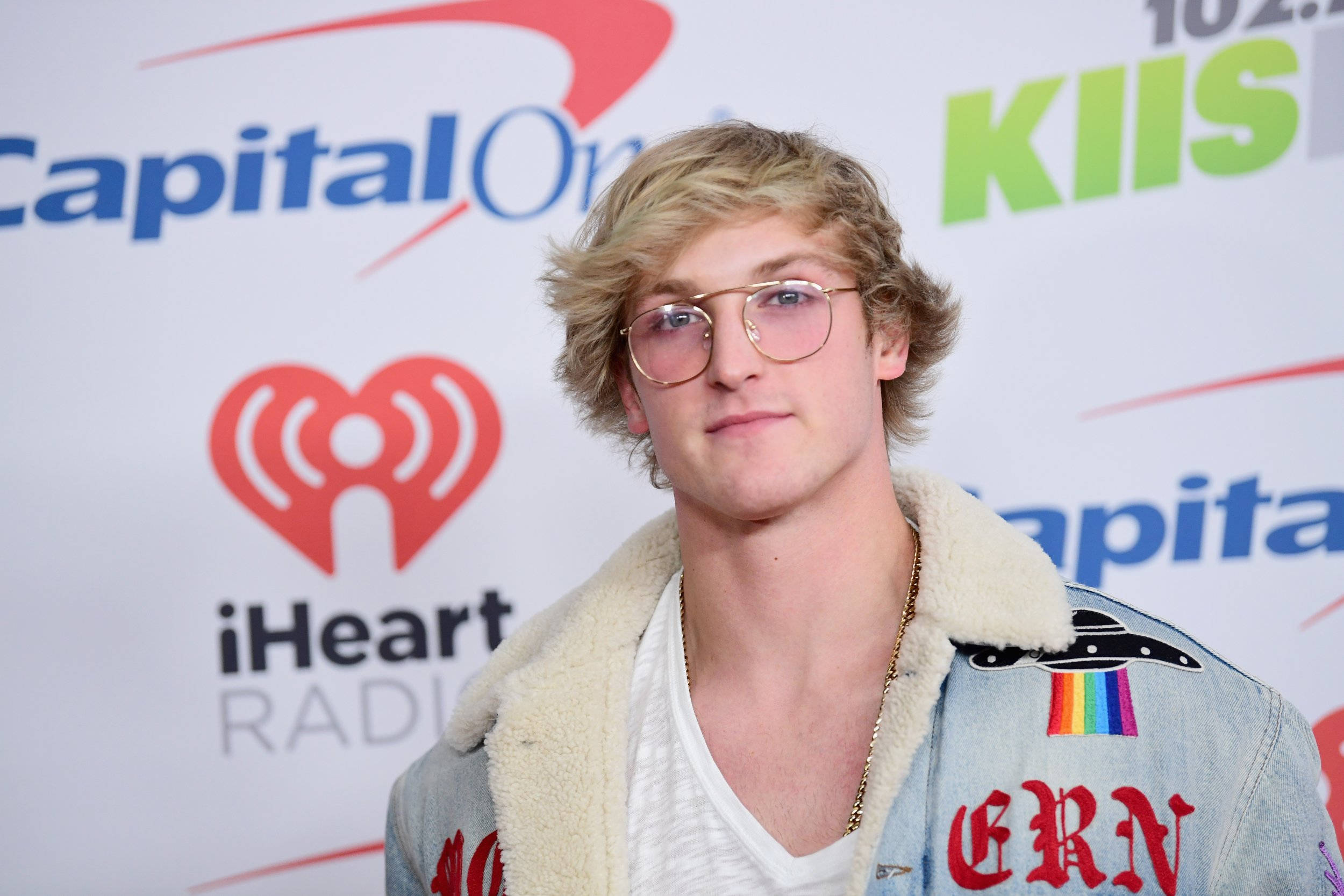 Logan 桌布 壁紙 — 一位金髮戴眼鏡的年輕男子，在Capital One iHeartRadio活動中穿著帶有彩虹補丁的牛仔外套。