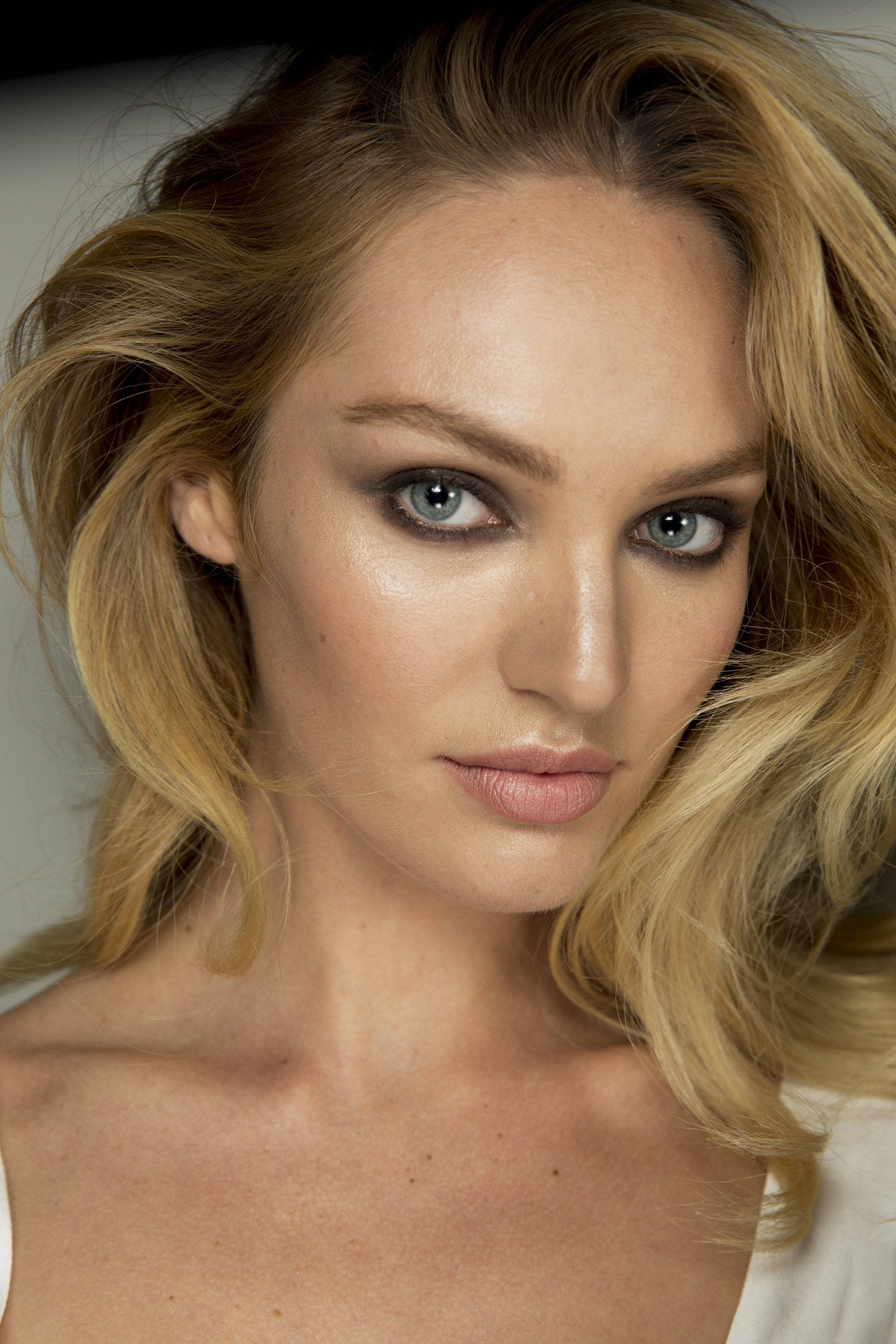 Candice 桌布 壁紙 — 一位金髮波浪長髮、擁有迷人藍眼睛的女性特寫肖像，直視鏡頭。