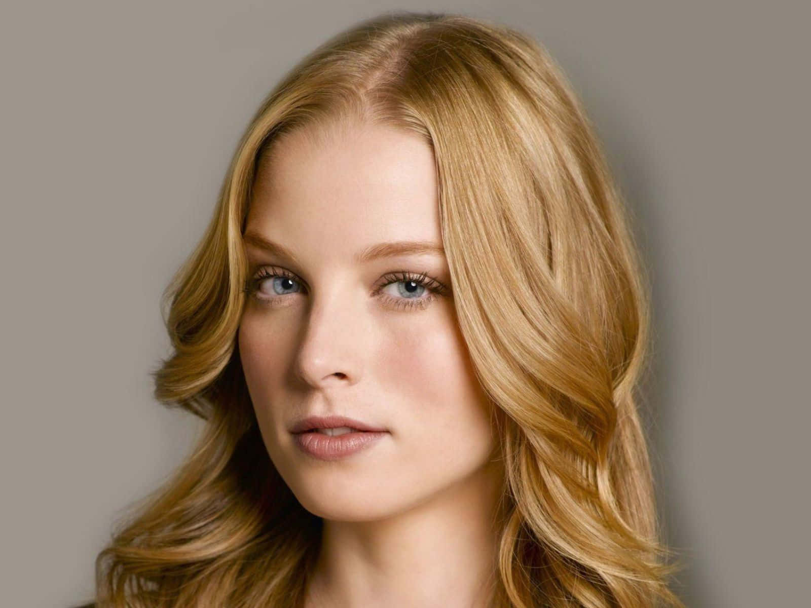 rachel nichols 桌布 壁紙 — 一位金髮波浪長髮、藍眼睛的女性在灰色中性背景下的特寫肖像。