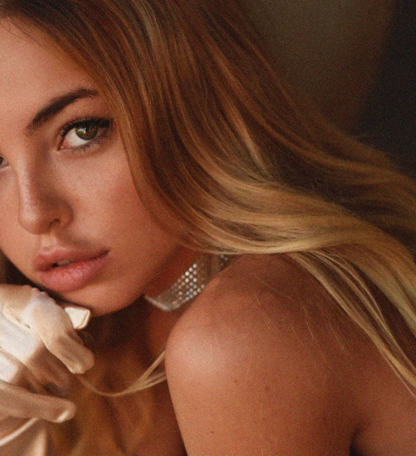 Emma Kotos 桌布 壁紙 — 一位金髮碧眼、戴著珍珠項鍊和白色手套的女子的特寫肖像。