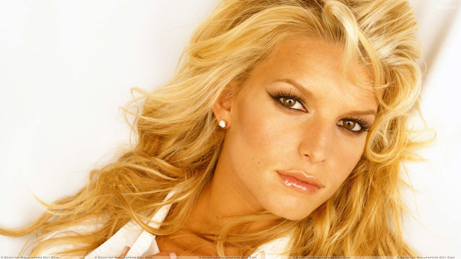 jessica simpson 桌布 壁紙 — 一位金髮碧眼、波浪長髮的女性特寫肖像，煙燻妝的眼睛直視鏡頭，背景為純白色。