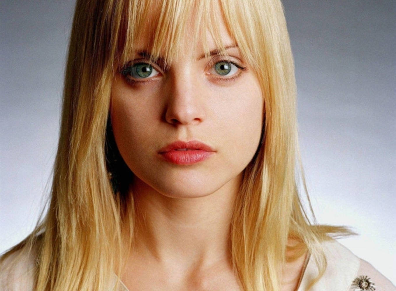 Beautiful Face 桌布 壁紙 — 一位金髮碧眼、表情嚴肅的女性特寫肖像，背景為柔和的灰色。