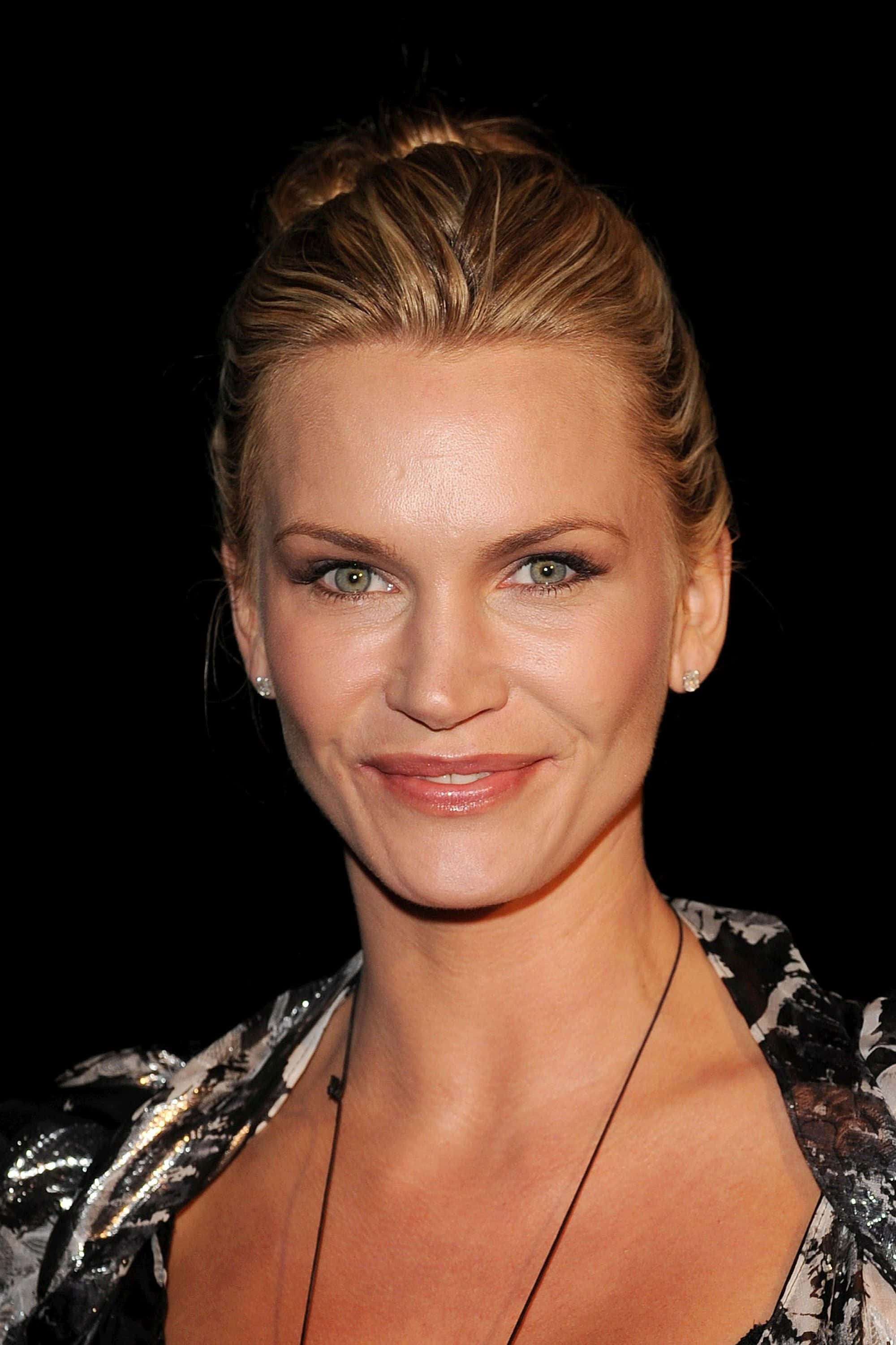 Natasha Henstridge 桌布 壁紙 — 一位金髮碧眼女子在黑色背景前微笑的特寫肖像。