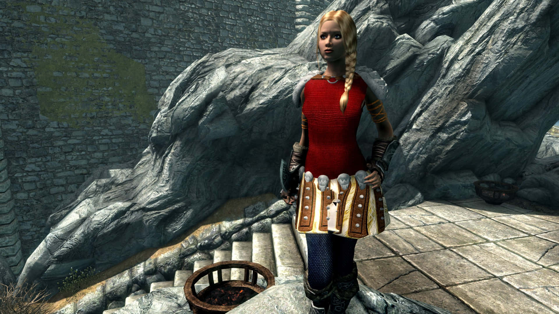Skyrim Astrid 桌布 壁紙 — 一位金髮穿紅色長袍的裝甲女士站在石階上，旁邊有一個巨大的灰色龍頭雕塑。
