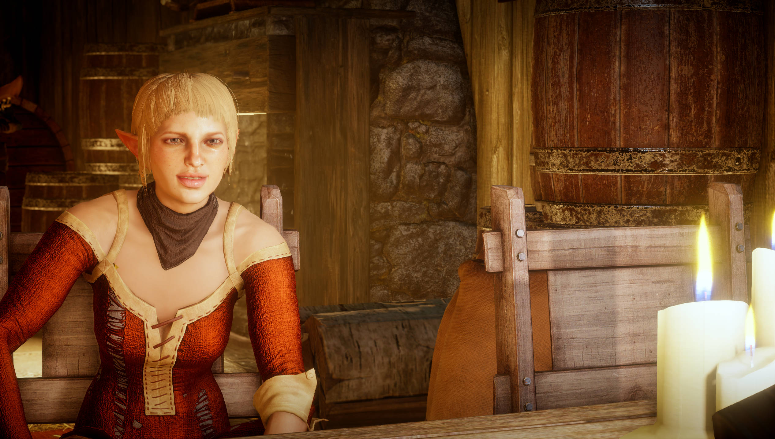 Dragon Age 桌布 壁紙 — 一位金髮精靈女子身穿紅色束腰連衣裙，坐在鄉村酒館的木桌旁，燭光搖曳。