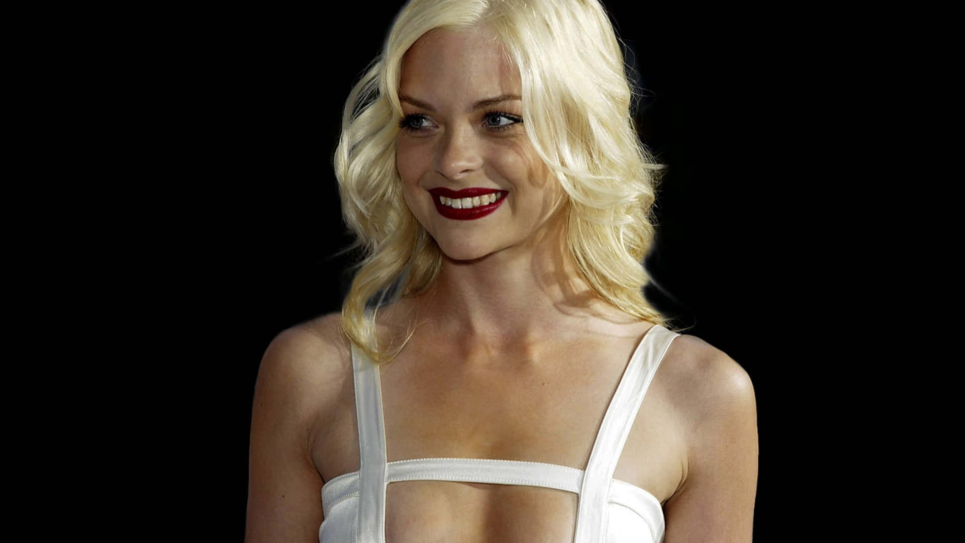 Jaime King 桌布 壁紙 — 一位金髮紅唇的女性在黑色背景下穿著白色上衣，露出溫暖的笑容。