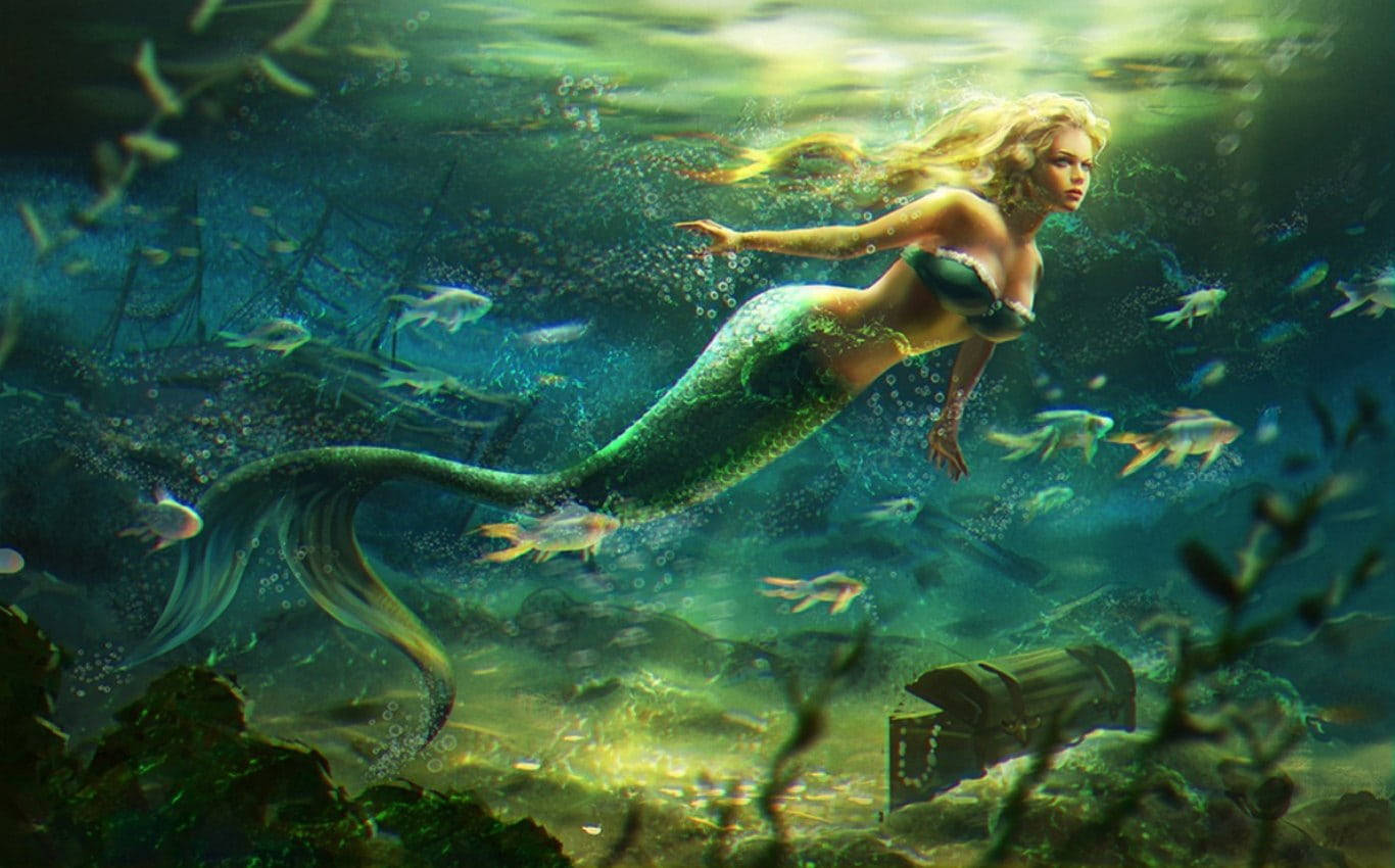 Beautiful Fish 桌布 壁紙 — 一位金髮綠尾的美人魚在陽光普照的海洋中優雅地滑行，靠近一艘沉船和一個寶箱。