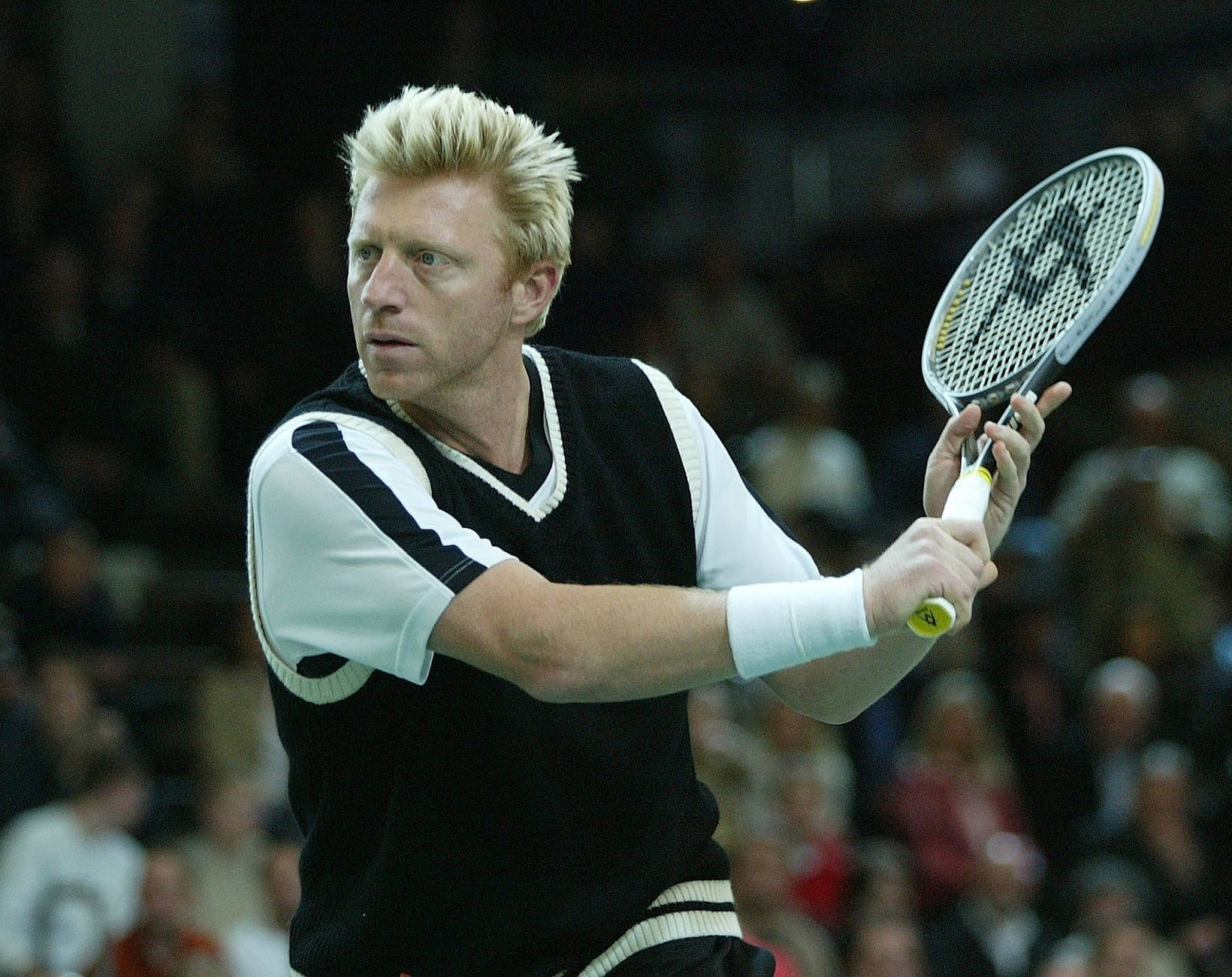 Boris Becker 桌布 壁紙 — 一位金髮網球選手穿著黑白裝備，在室內比賽中專注揮拍。