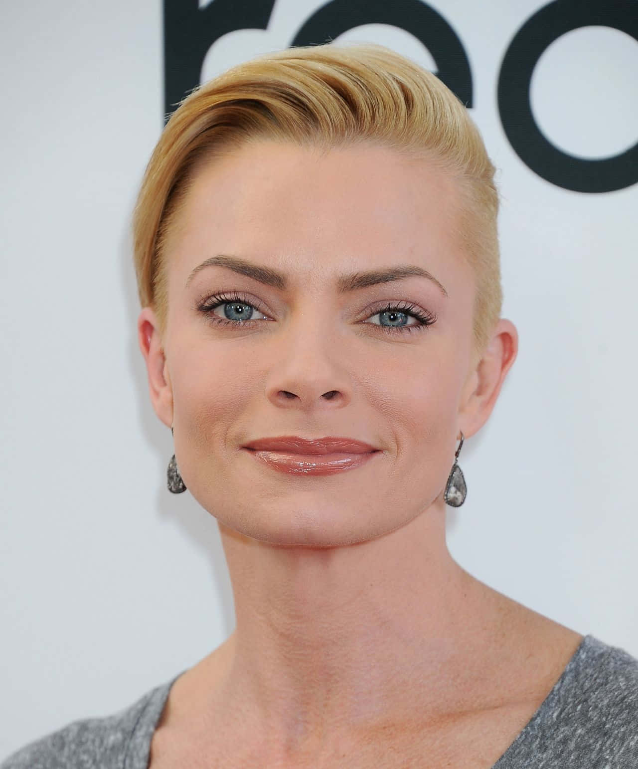 Jaime Pressly 桌布 壁紙 — 一位金髮藍眼女性的特寫肖像，對著鏡頭溫柔微笑。