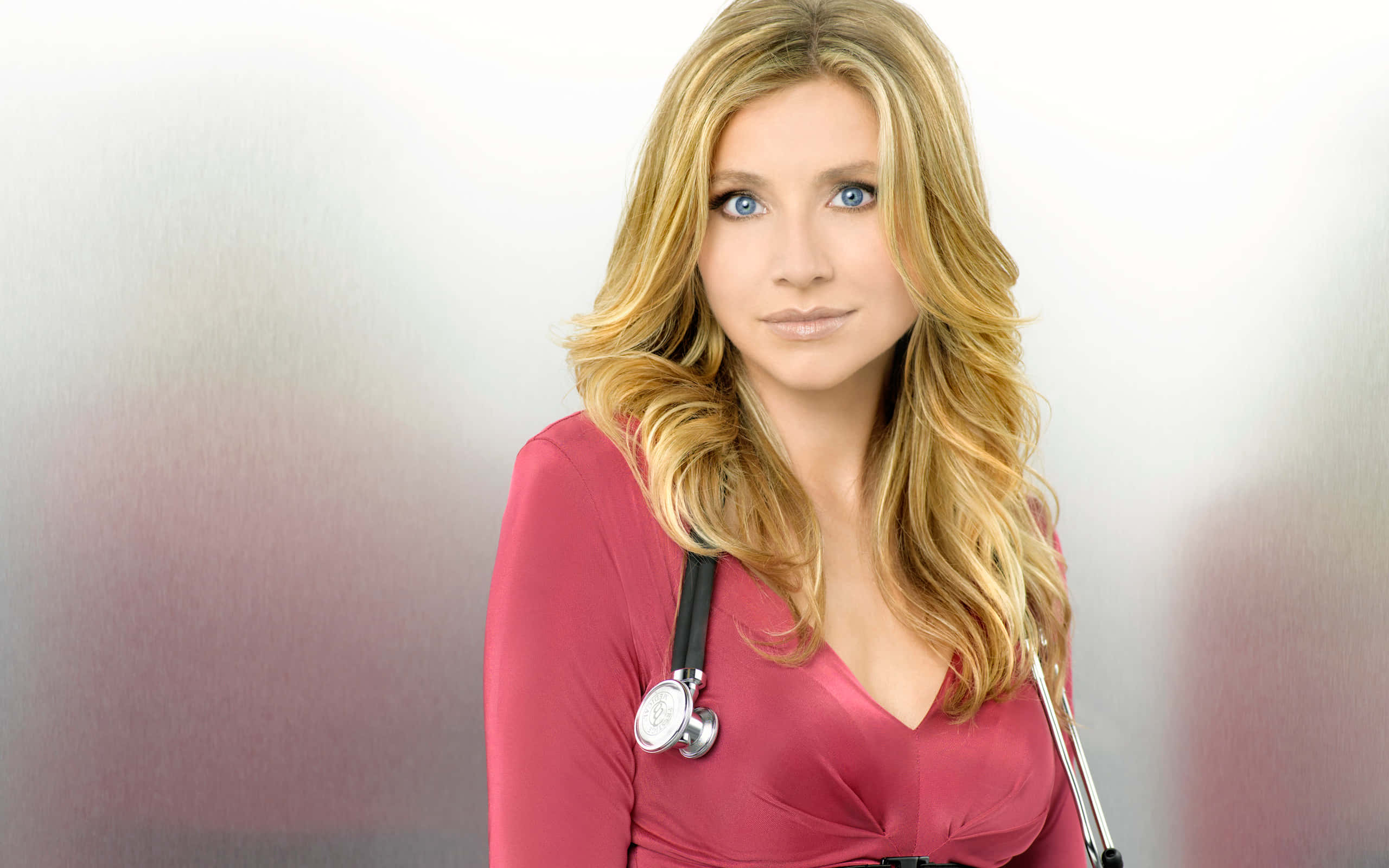 Sarah Chalke 桌布 壁紙 — 一位金髮藍眼女性穿著粉紅色上衣並掛著聽診器，背景為柔和漸變色。