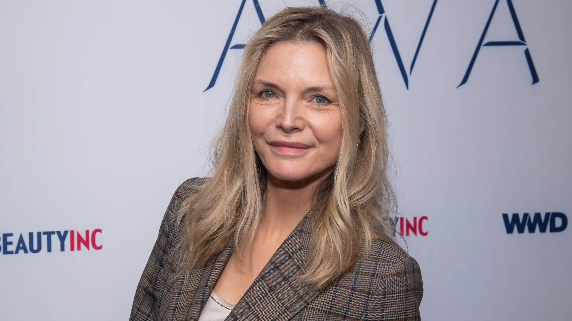 Celebrity 桌布 壁紙 — 一位金髮藍眼的女士在美容業活動中，穿著格紋西裝外套微笑。