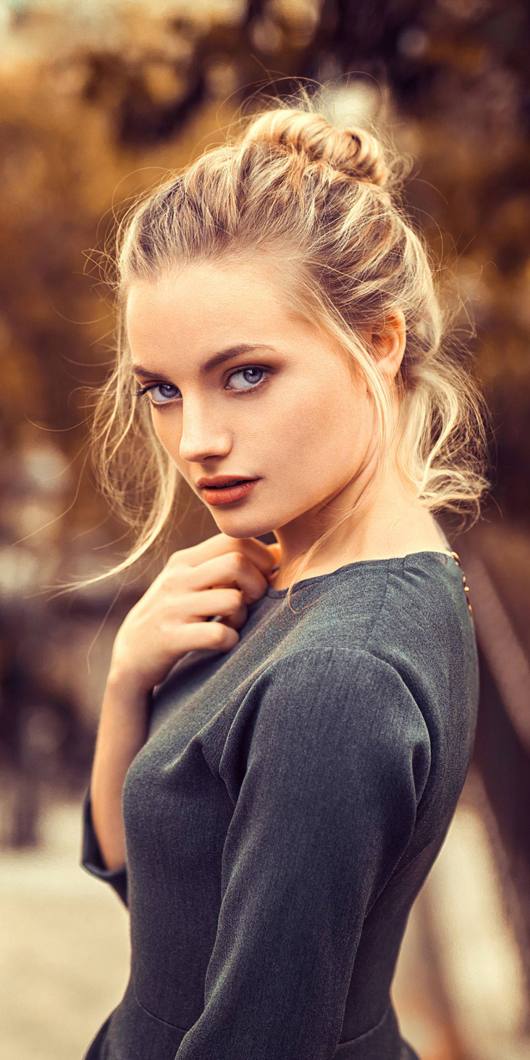 hair 桌布 壁紙 — 一位金髮藍眼的女性穿著深灰色連衣裙在戶外直視鏡頭。
