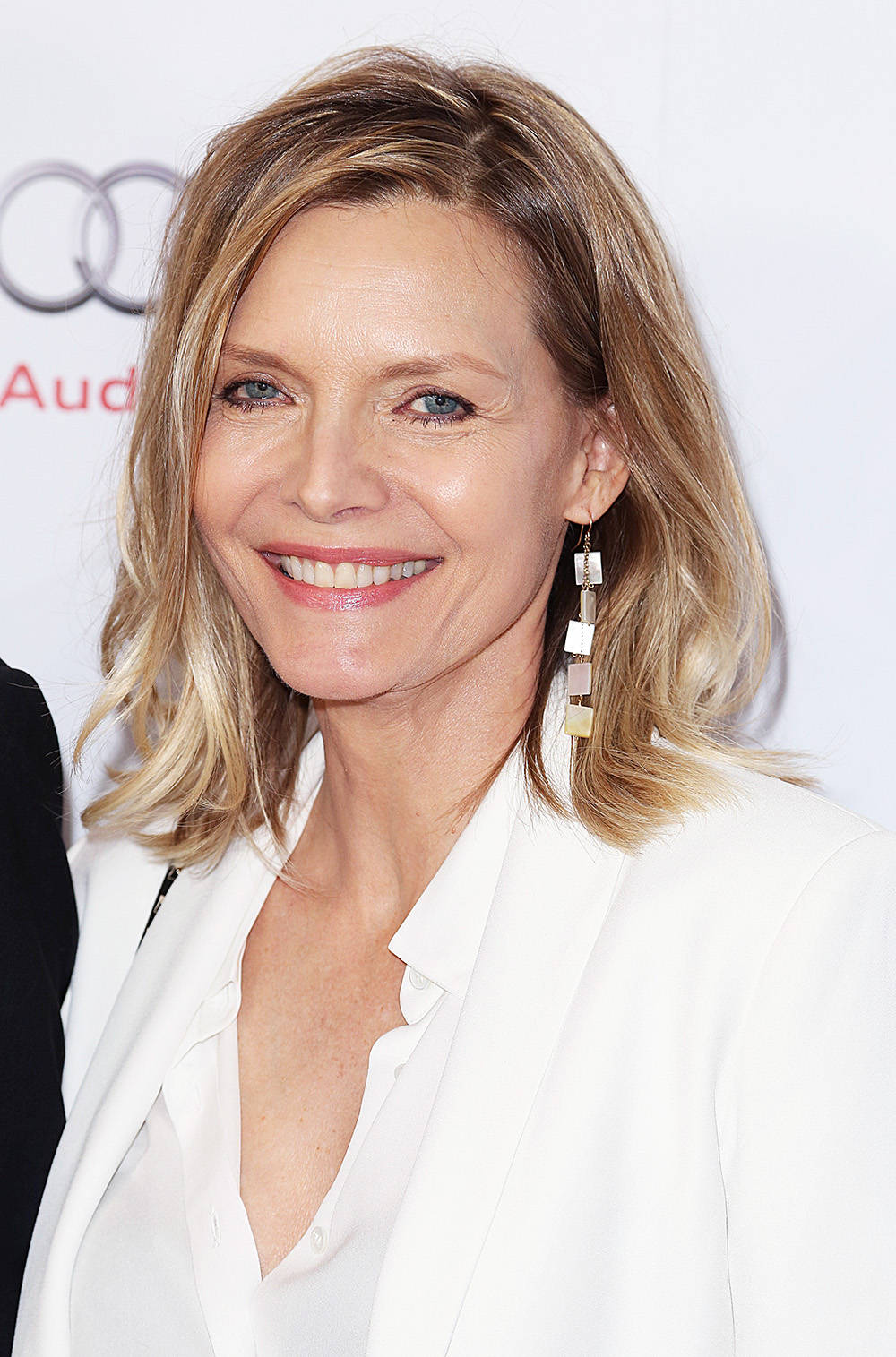 Celebrity 桌布 壁紙 — 一位金髮藍眼的微笑女士穿著白色西裝外套和垂墜耳環，參加Audi活動。